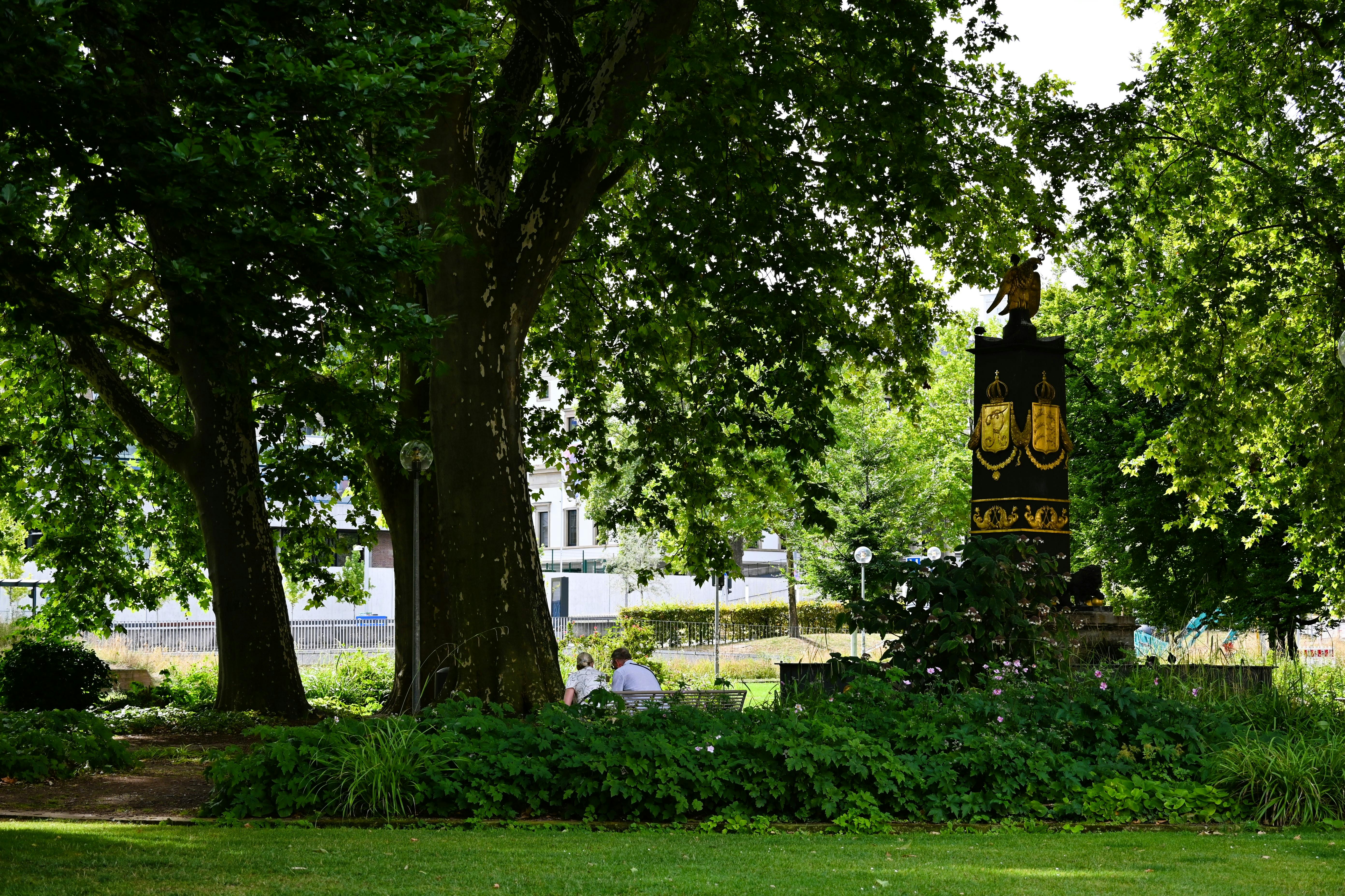 Gratis Un momento di relax in un parco lussureggiante con un monumento storico e una vegetazione rigogliosa. Foto a disposizione