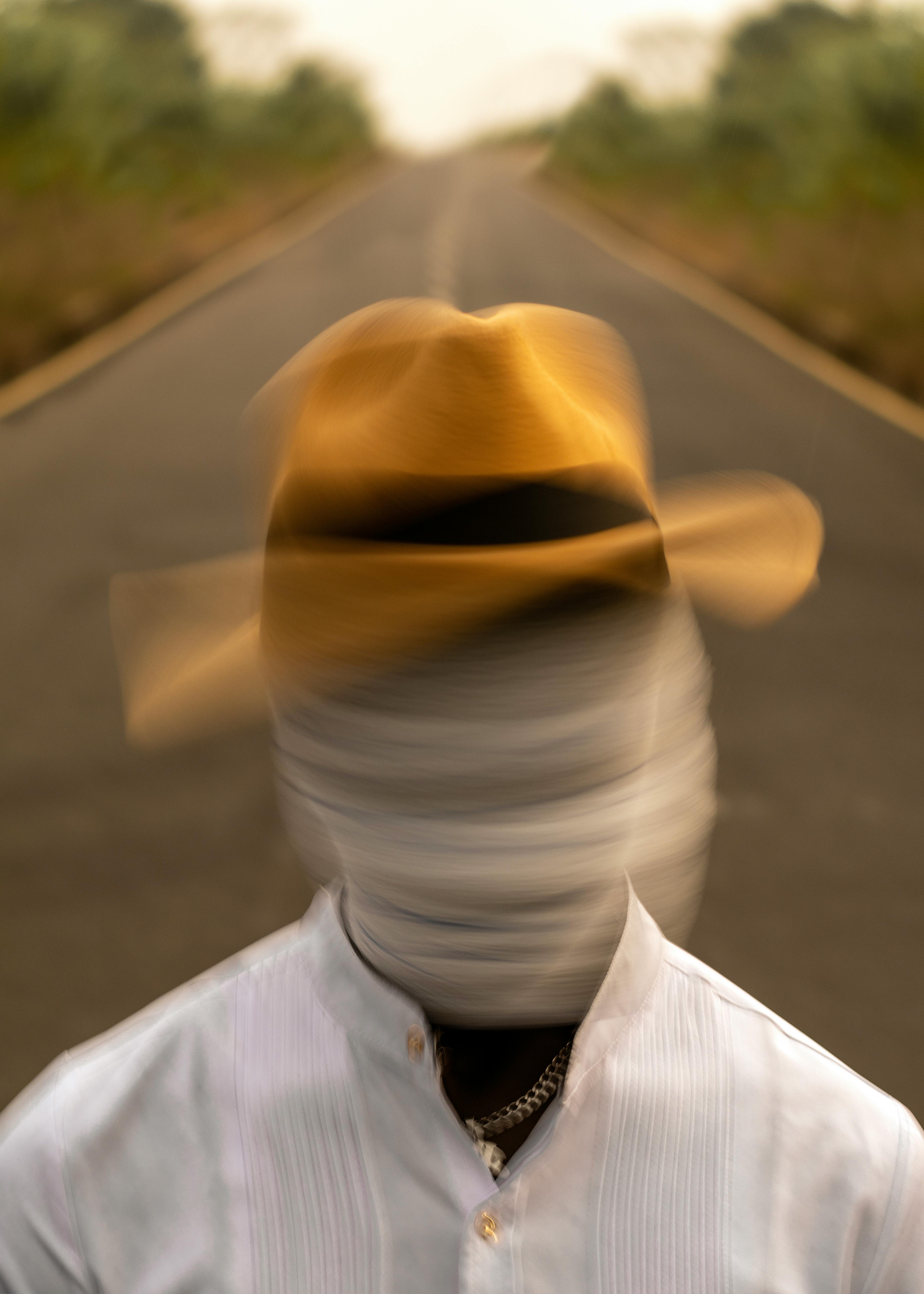 Gratuit Portret misterios cu față și mișcare încețoșată pe un drum pustiu, purtând o pălărie. Fotografie de stoc