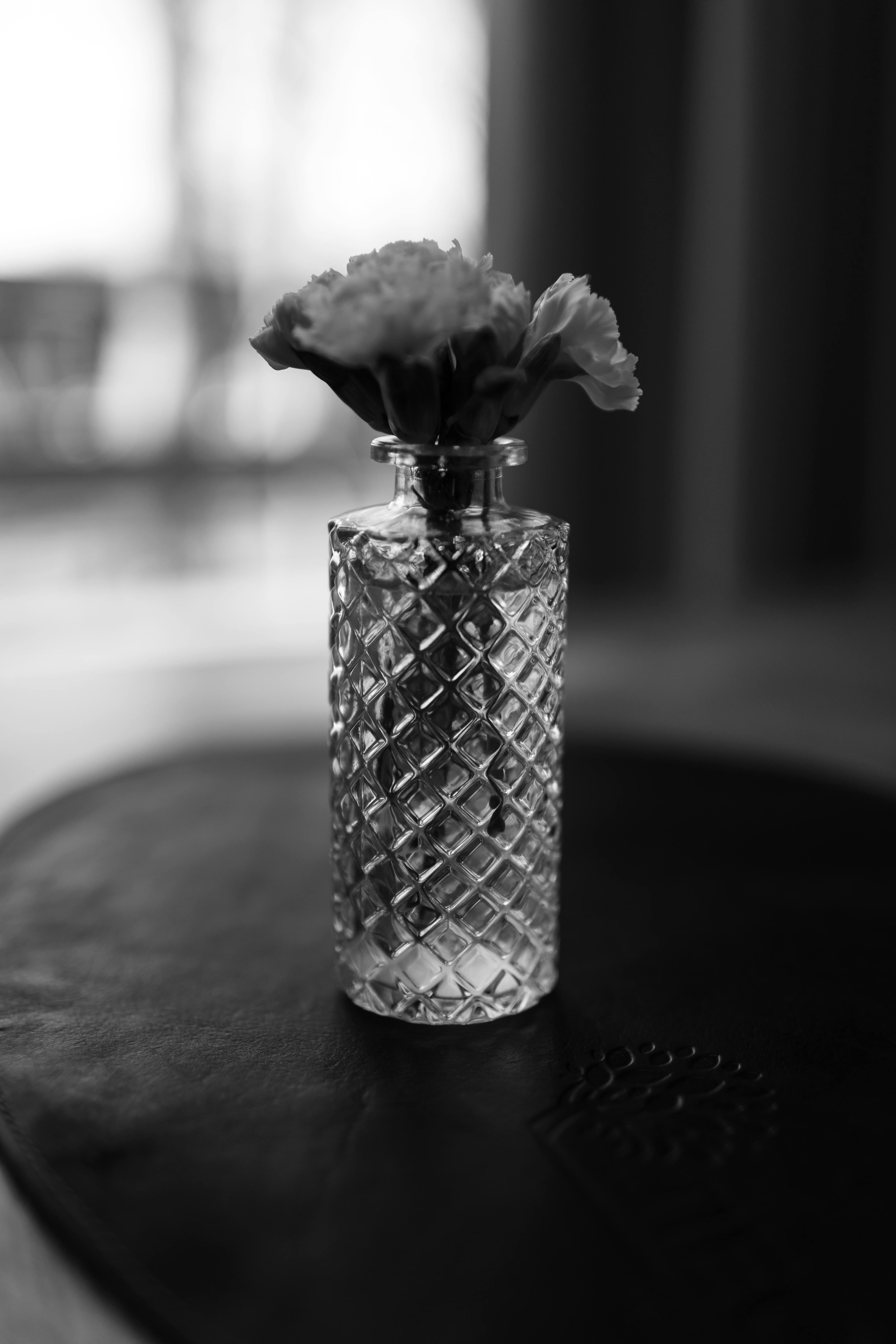 De franc Fotografia en blanc i negre de flors en un gerro de vidre sobre una taula. Foto d'estoc