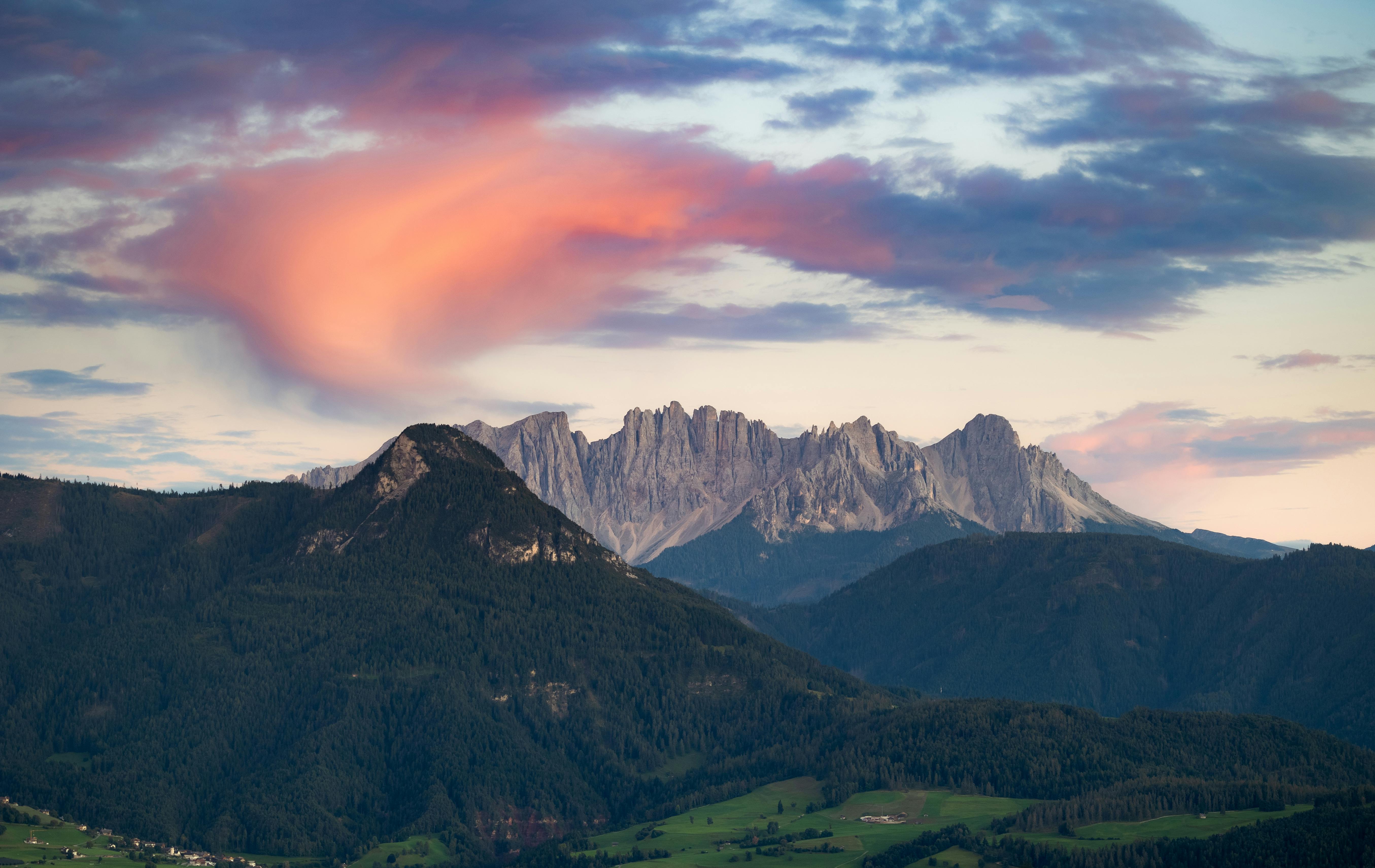 Gratis Uno spettacolo mozzafiato delle Dolomiti al tramonto, con nuvole dai colori vivaci e cime aspre. Foto a disposizione