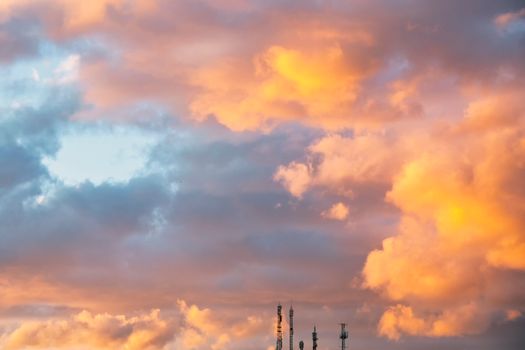 Een prachtige zonsondergang met levendige wolken en silhouetten van zendmasten.