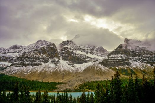 Stunning view of Bow Lake and Crowfoot Mountain shrouded in clouds at sunset, Banff National Park.