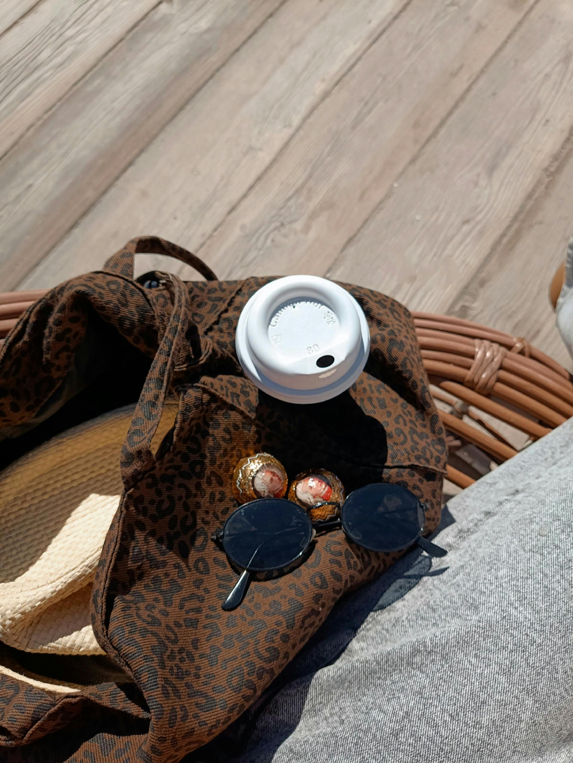 Miễn phí Kính râm, cốc cà phê và mũ rơm trên một chiếc túi họa tiết, thích hợp cho một ngày hè thư giãn. Ảnh lưu trữ