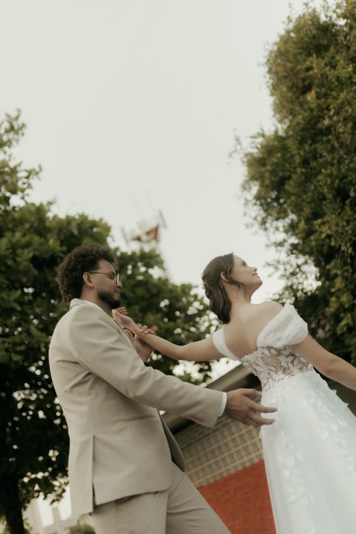 Free Bride and groom dancing outdoors, capturing a romantic moment in an elegant setting. Stock Photo