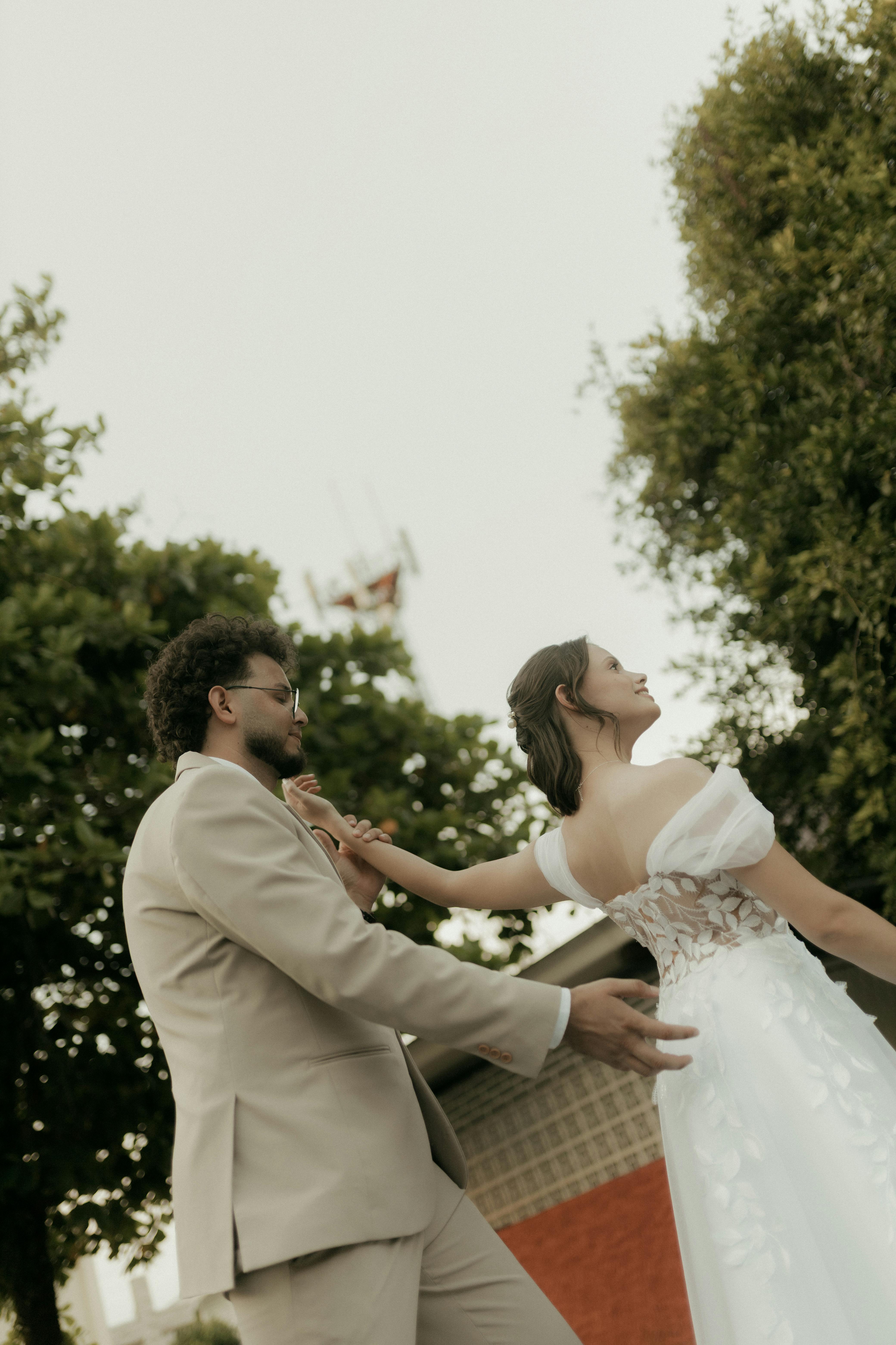 Ücretsiz Gelin ve damat açık havada dans ederken, zarif bir ortamda romantik bir anı ölümsüzleştirdiler. Stok Fotoğraflar