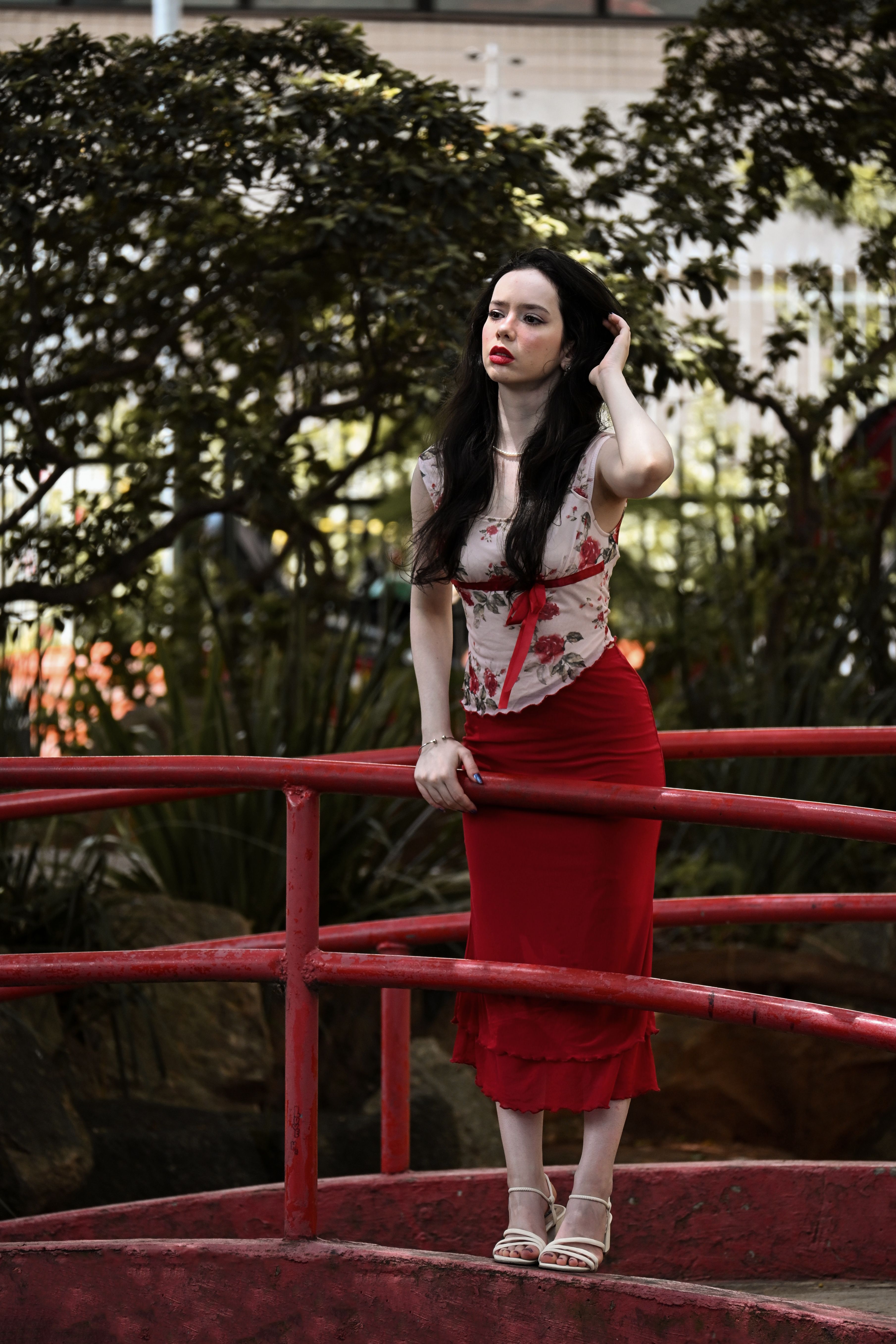 Woman in Red Dress Posing by Park Railing · Free Stock Photo