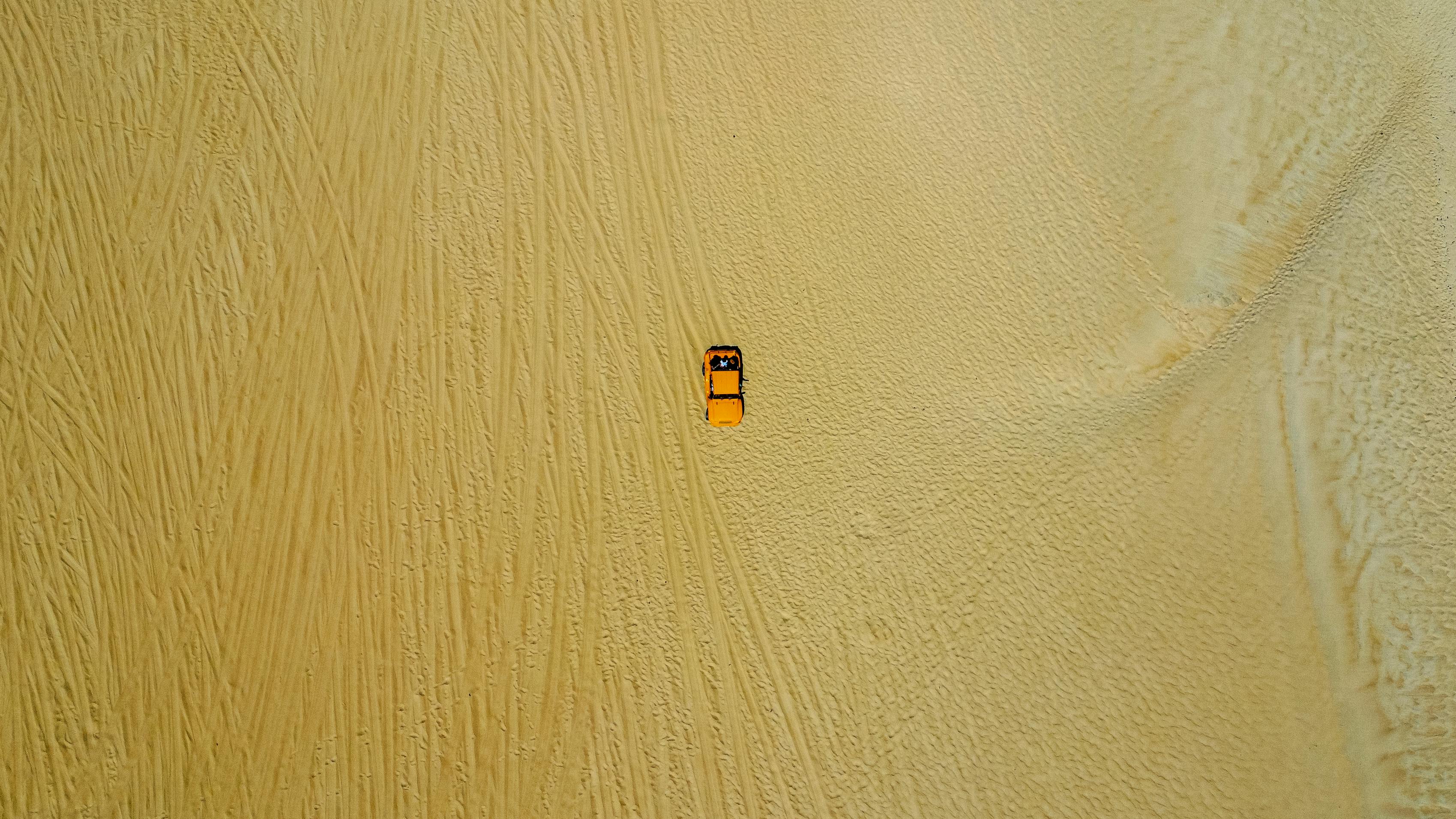 gratis Luchtfoto van een gele auto die over zandduinen rijdt in Natal, Brazilië. Een fascinerend reisconcept. Stockfoto