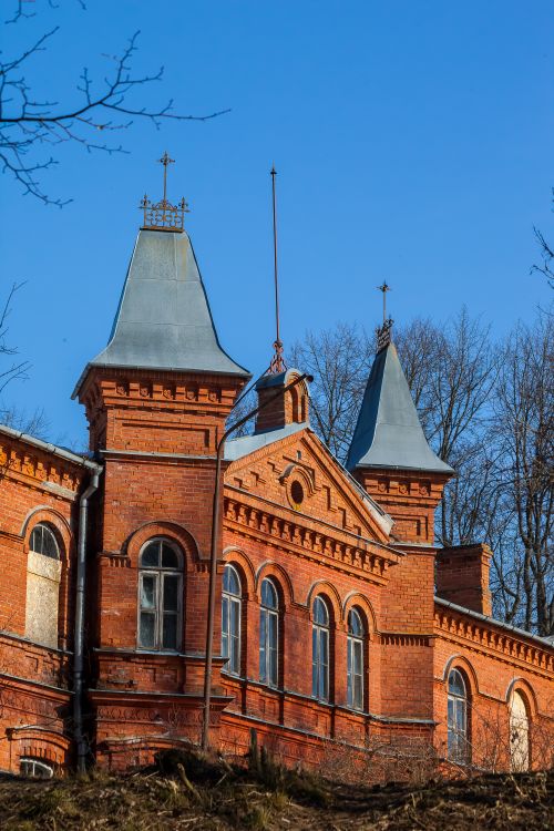 Free A classic red brick mansion featuring Victorian-style towers against a clear blue sky. Stock Photo
