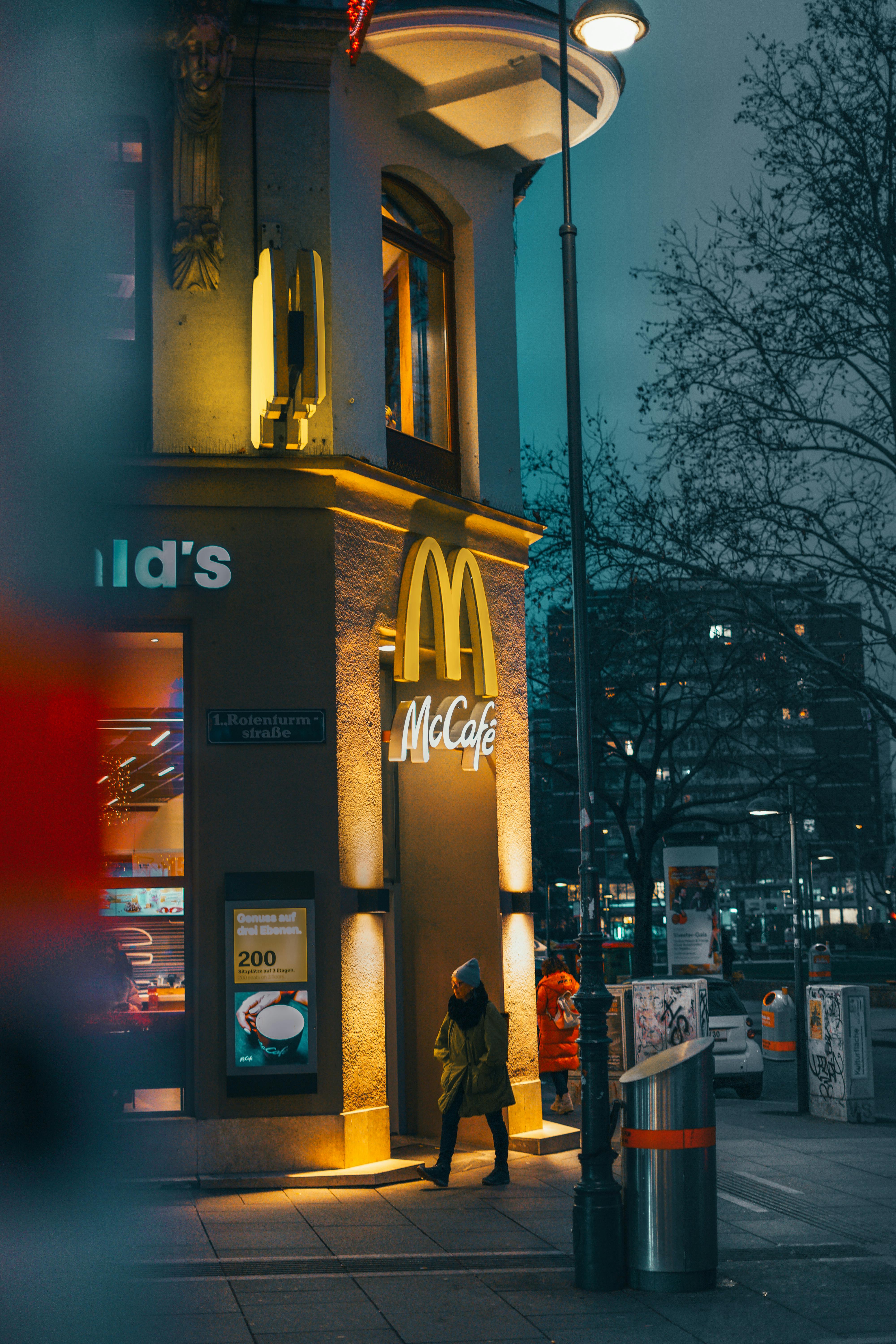 Kostenlos Beleuchtete McCafé-Ecke bei Nacht in Wien, Österreich, wo Fußgänger die Atmosphäre der Stadt erleben. Stock-Foto
