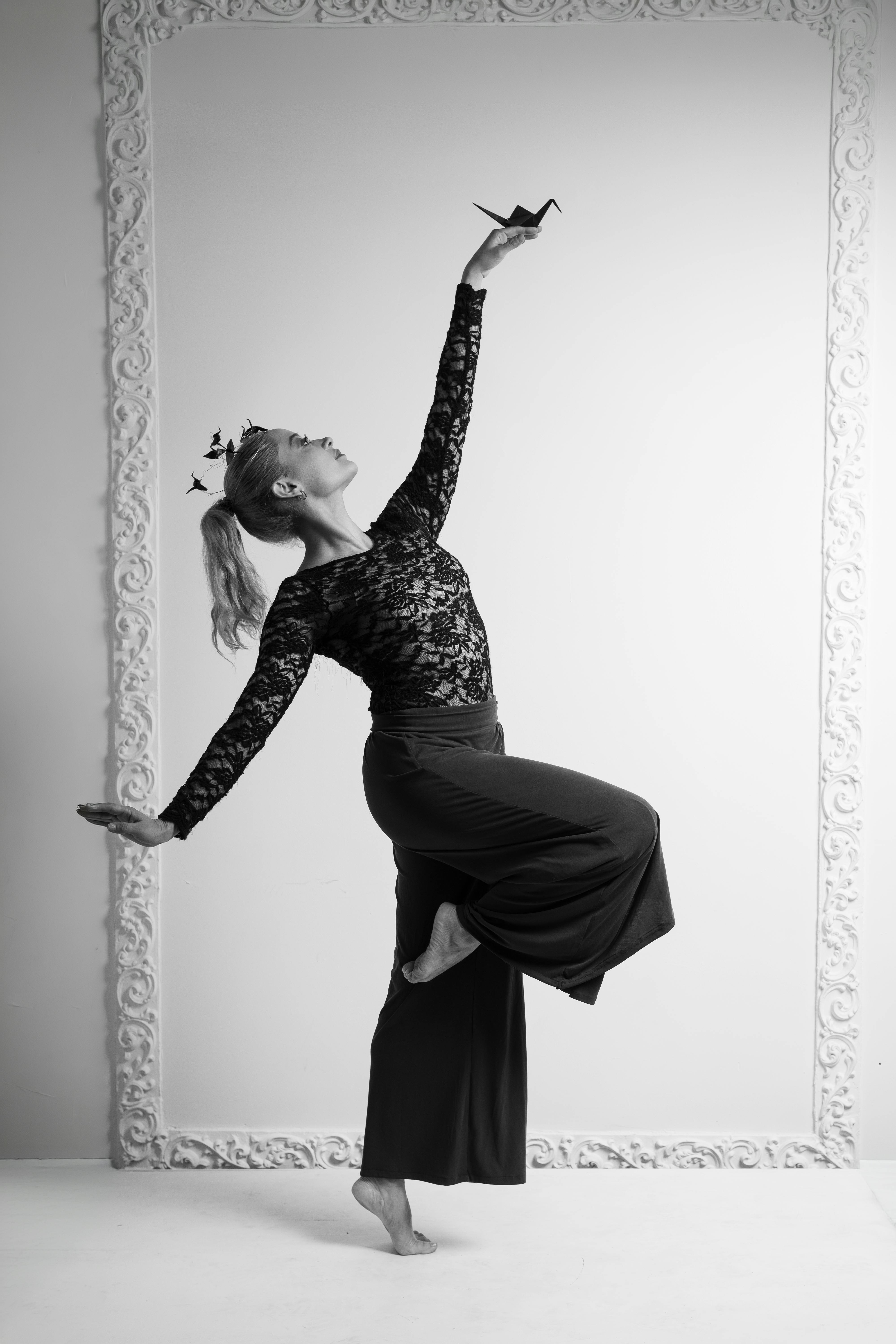 Miễn phí Một vũ công đương đại thực hiện tư thế giữ thăng bằng với tác phẩm điêu khắc origami tsuru. Ảnh lưu trữ