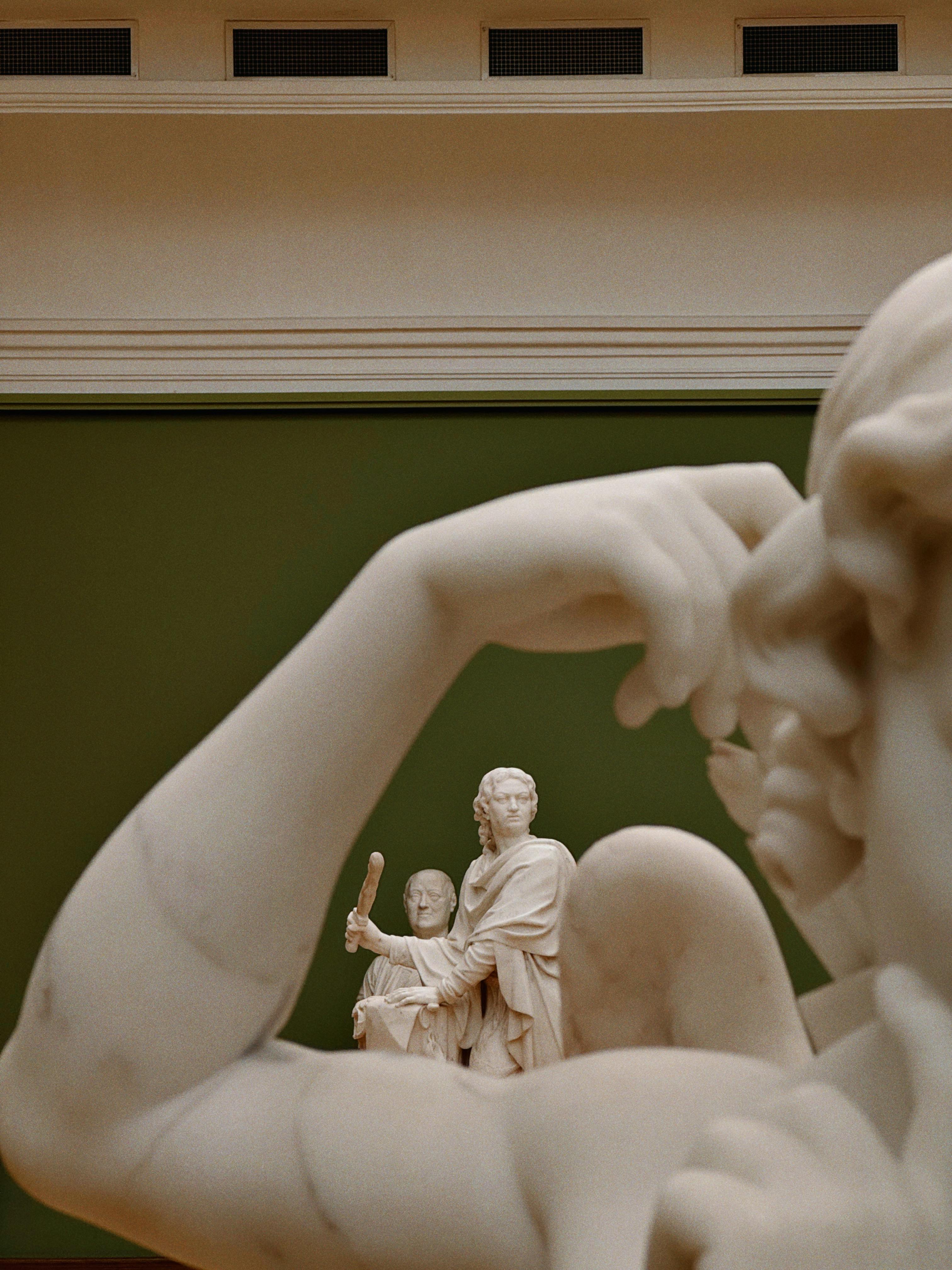 De franc Primer pla d'escultures de marbre en una galeria d'art interior amb il·luminació elegant. Foto d'estoc