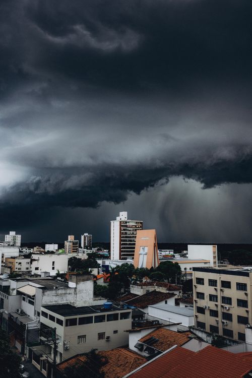 Free Dark storm clouds loom over a cityscape, highlighting the contrast between nature and urban life. Stock Photo
