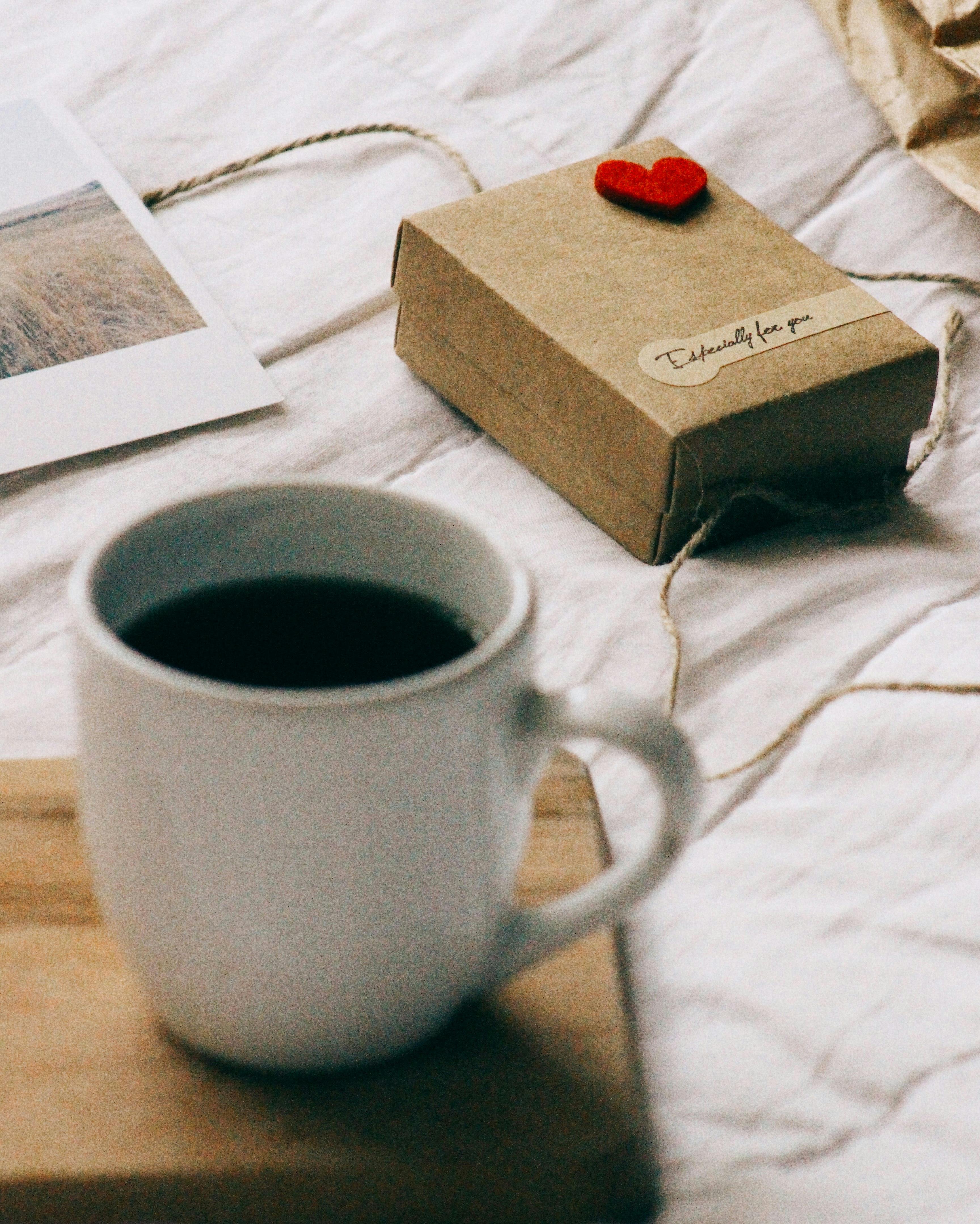 Free Warm scene of coffee and gift box on a cozy morning setting with a heartfelt note. Stock Photo
