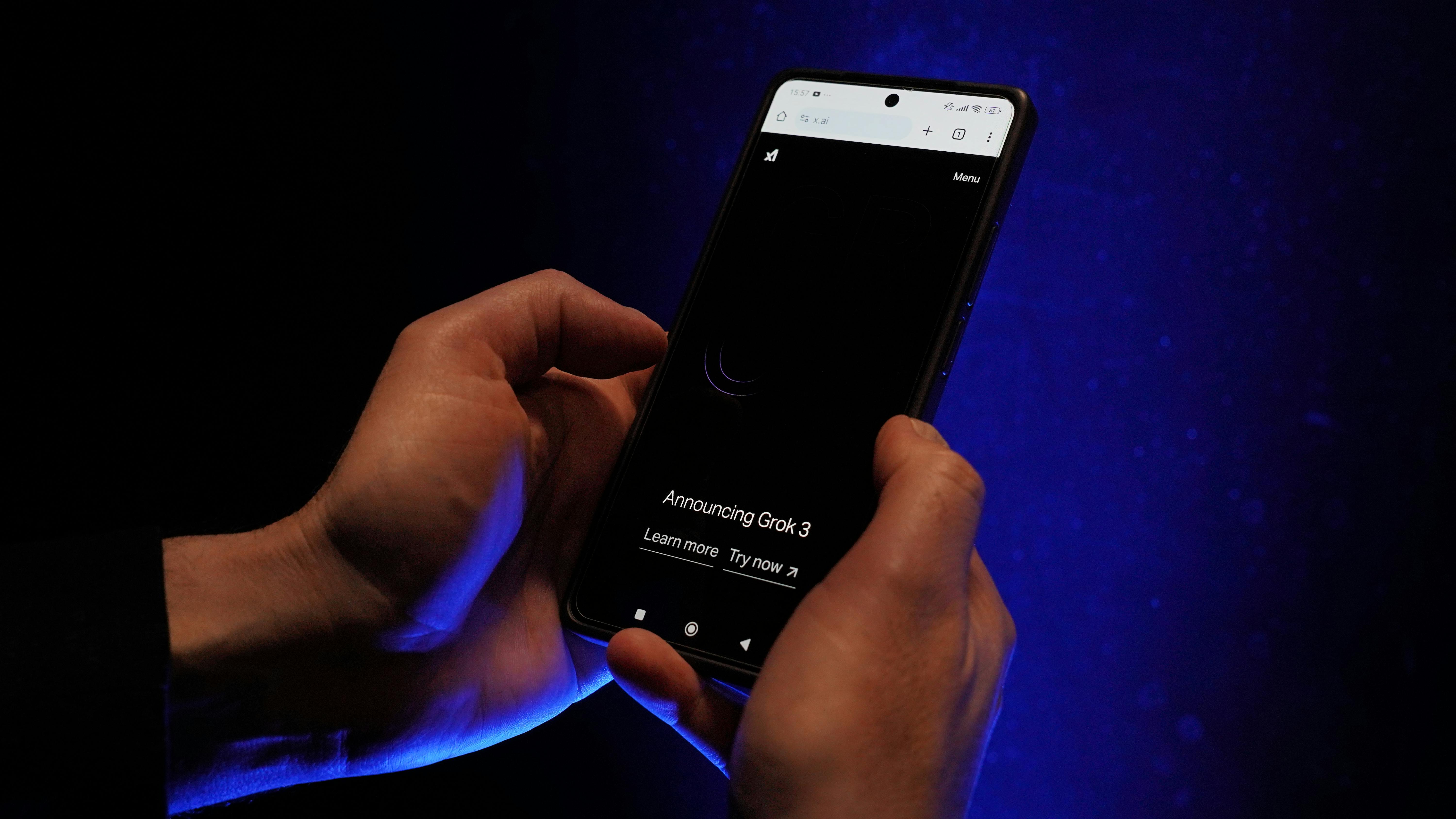 Close-up of hands holding a smartphone displaying 'Announcing Grok 3' on a dark background.