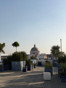 Rooftop garden view with iconic Puebla dome under clear sky.