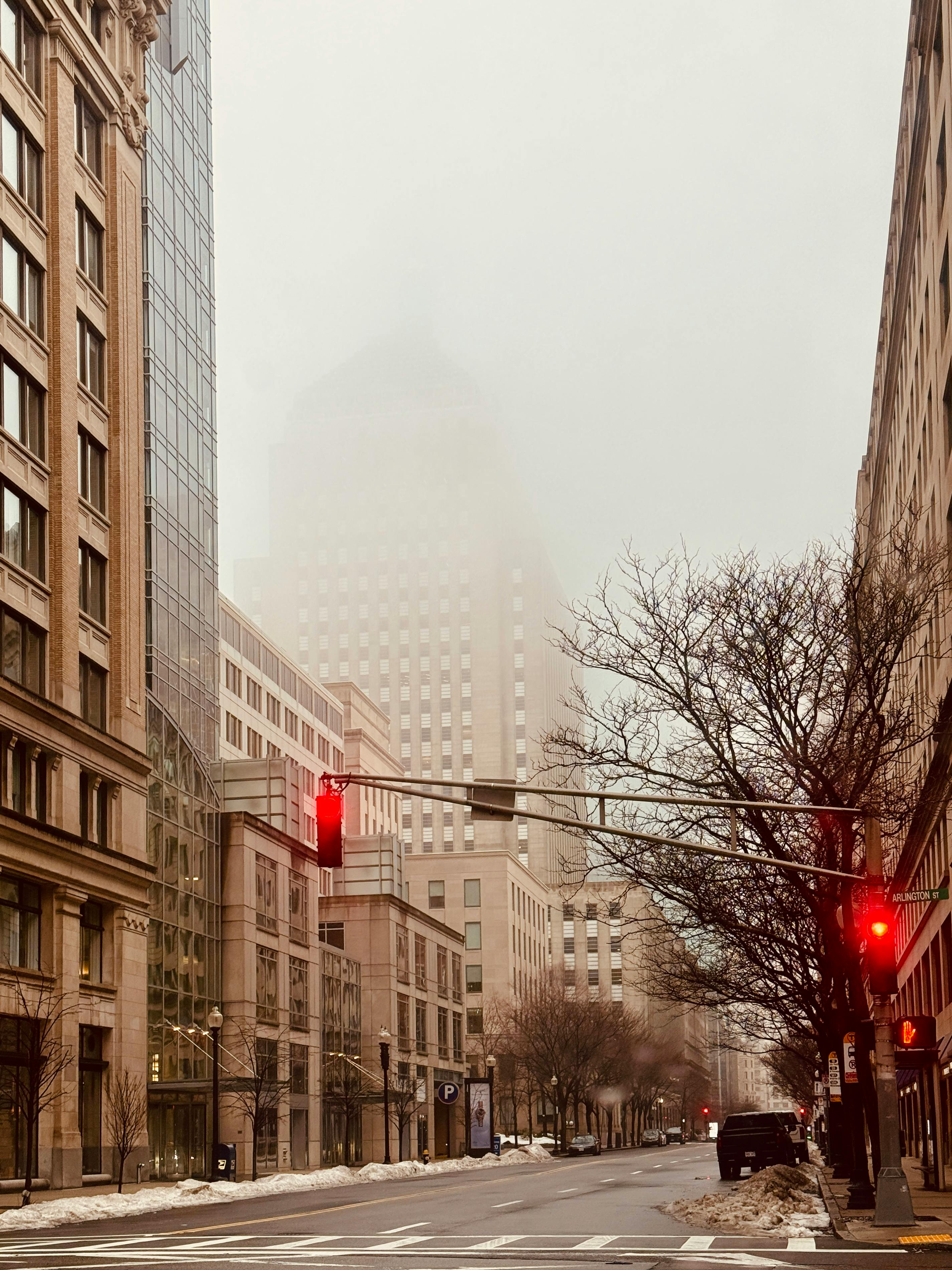 免费 波士顿雾气弥漫，高楼林立，一条安静的街道上有一盏红色的交通信号灯。 素材图片