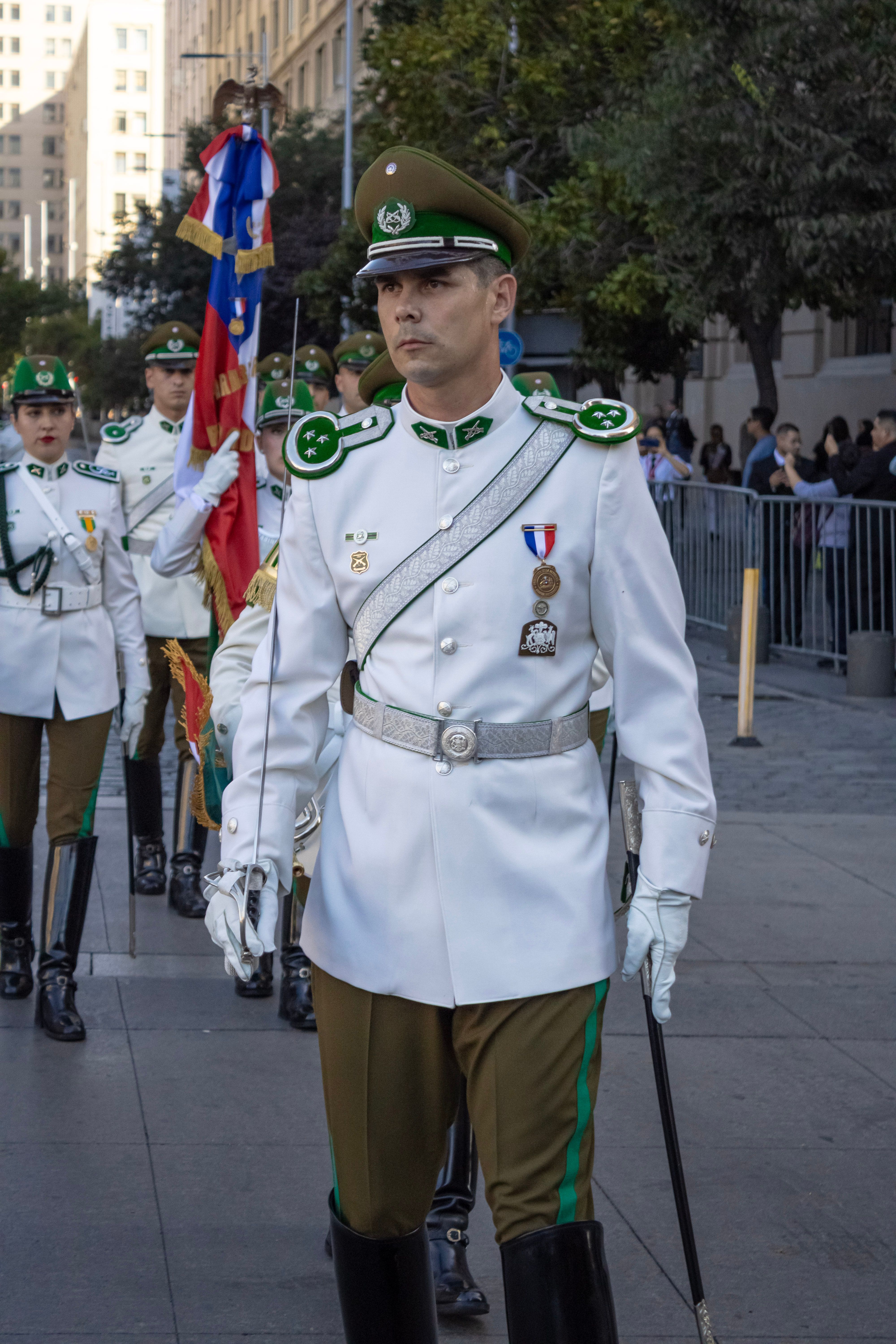 Uma procissão formal de oficiais da Carabinieri chilena em Santiago em um dia ensolarado.