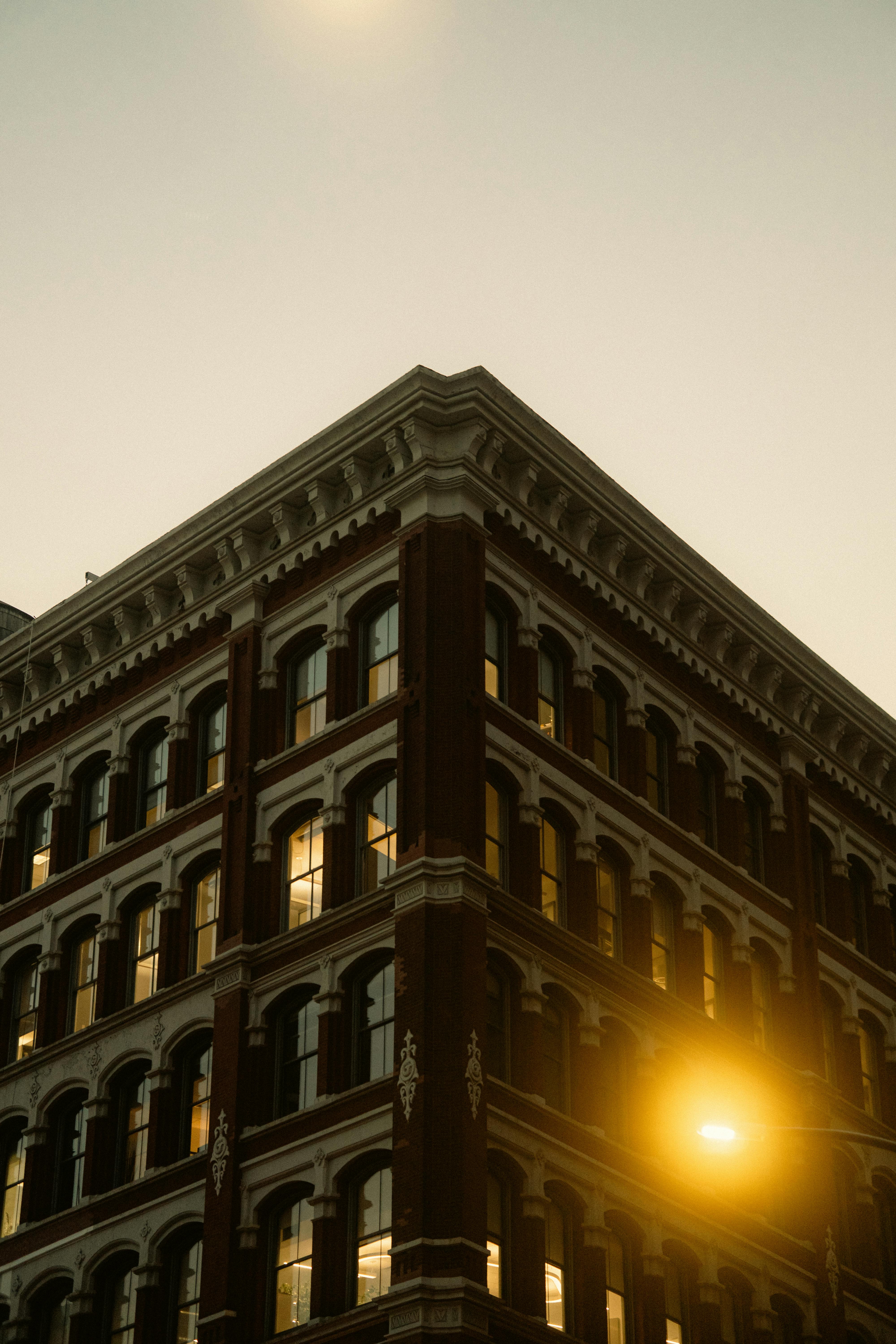 De franc Vista de cantonada d'un edifici vintage de Nova York al capvespre amb una càlida il·luminació del carrer. Foto d'estoc
