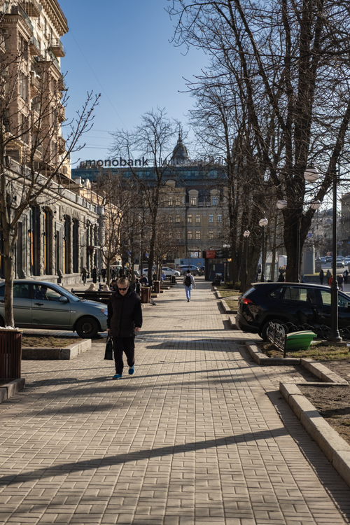Free Charming European street view with people walking under a clear sky. Stock Photo