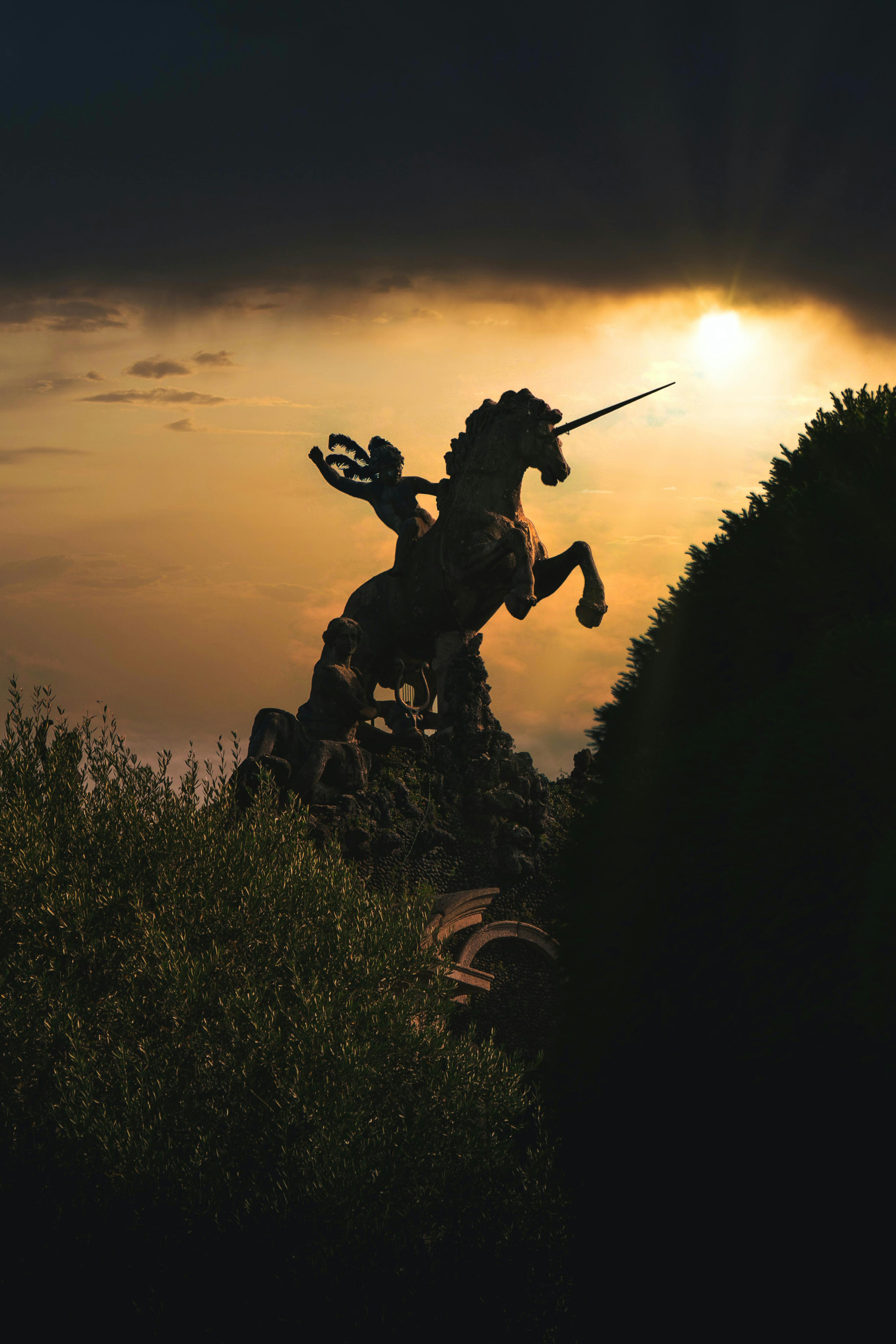 bezplatná Dramatická silueta sochy jednorožce proti zářivé obloze při západu slunce. Základová fotografie