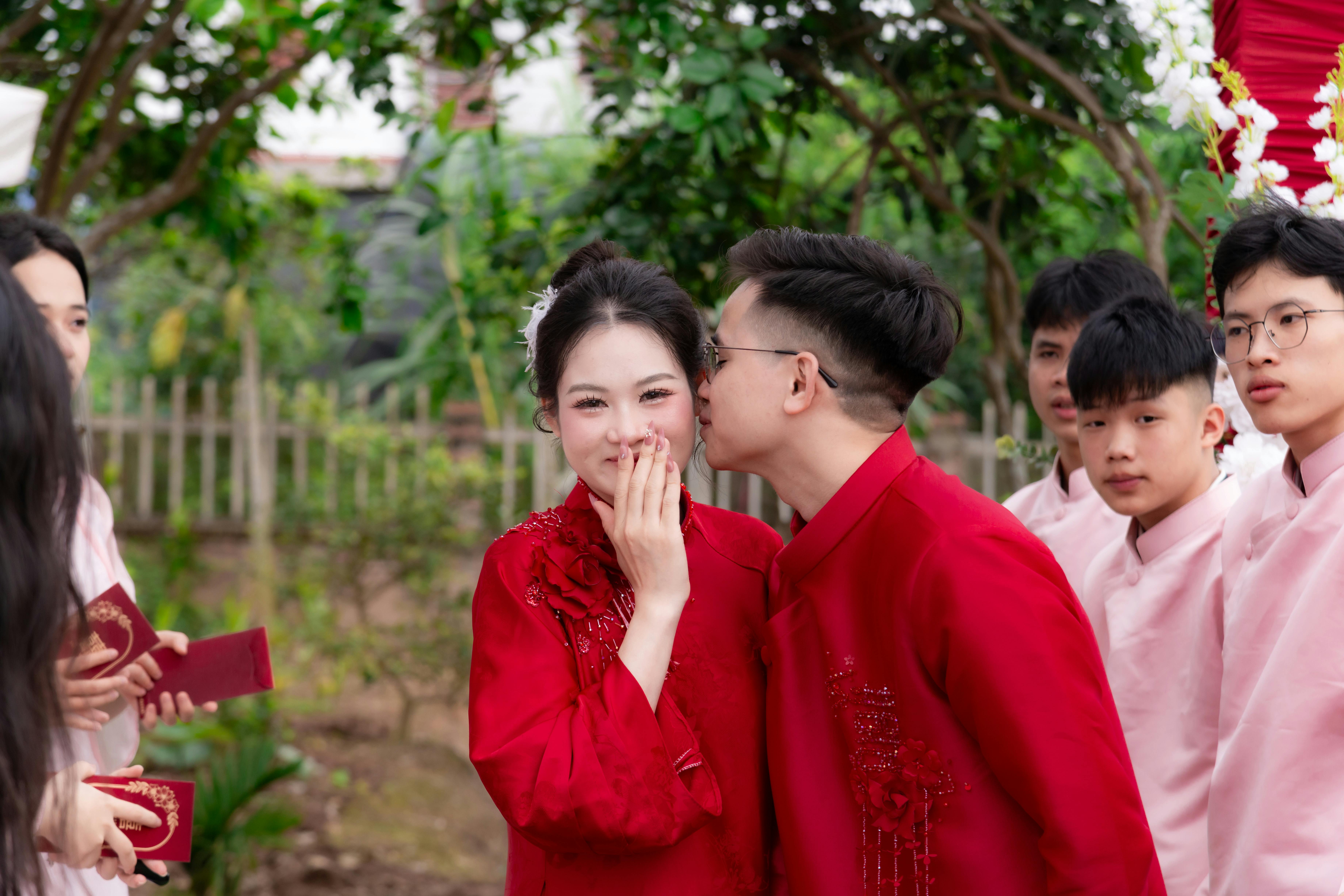 Gratuit Un couple célèbre une cérémonie de mariage asiatique traditionnelle en plein air, vêtu de tenues festives et affichant des expressions joyeuses. Photos