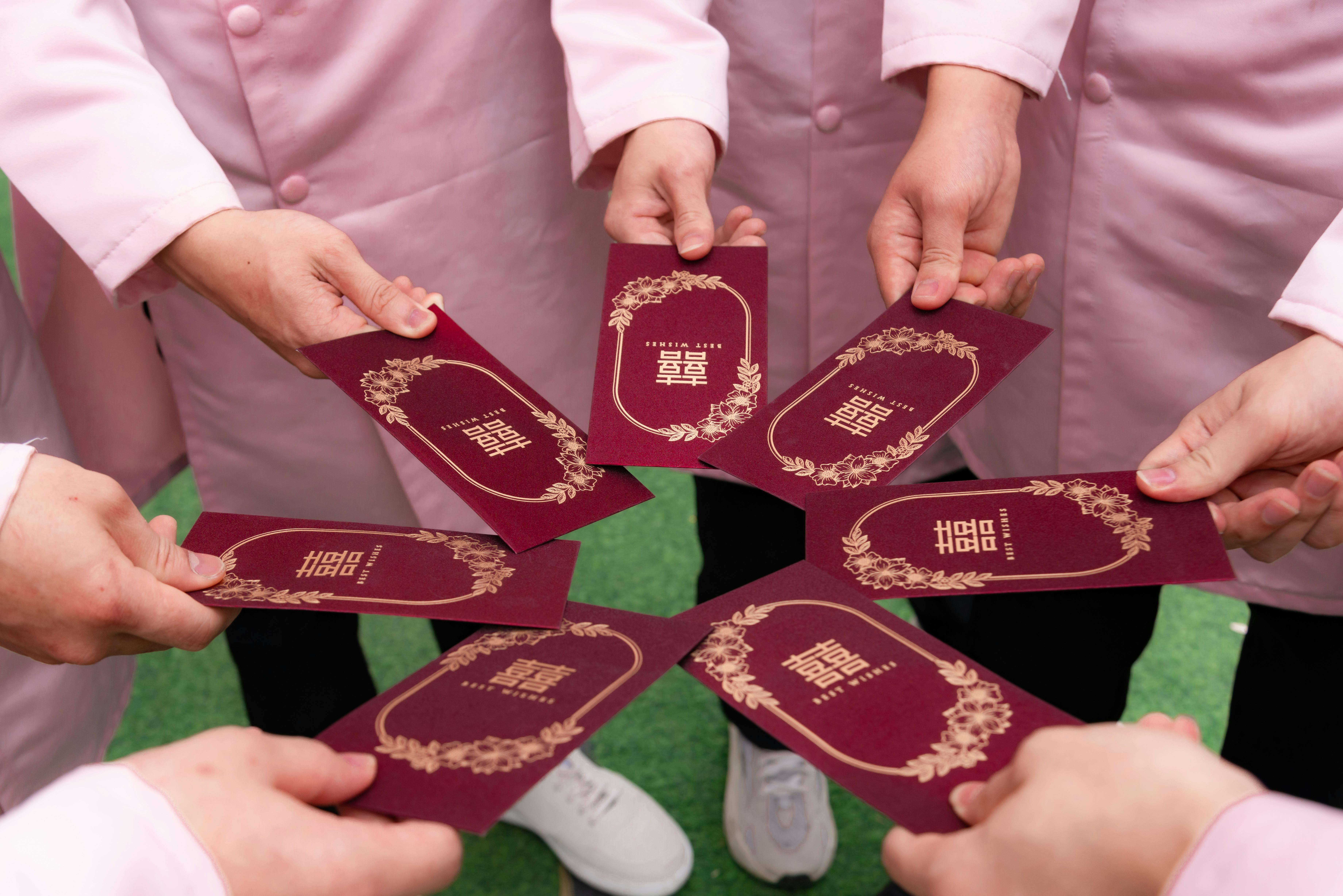 grátis Pessoas compartilhando envelopes vermelhos decorativos em uma celebração comunitária. Foto profissional