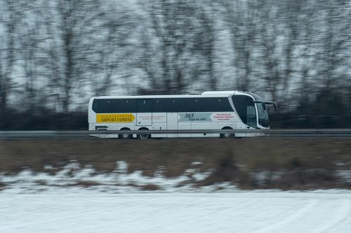 Free A dynamic shot of the Ingolstadt Airport Express bus speeding through a snowy landscape. Stock Photo