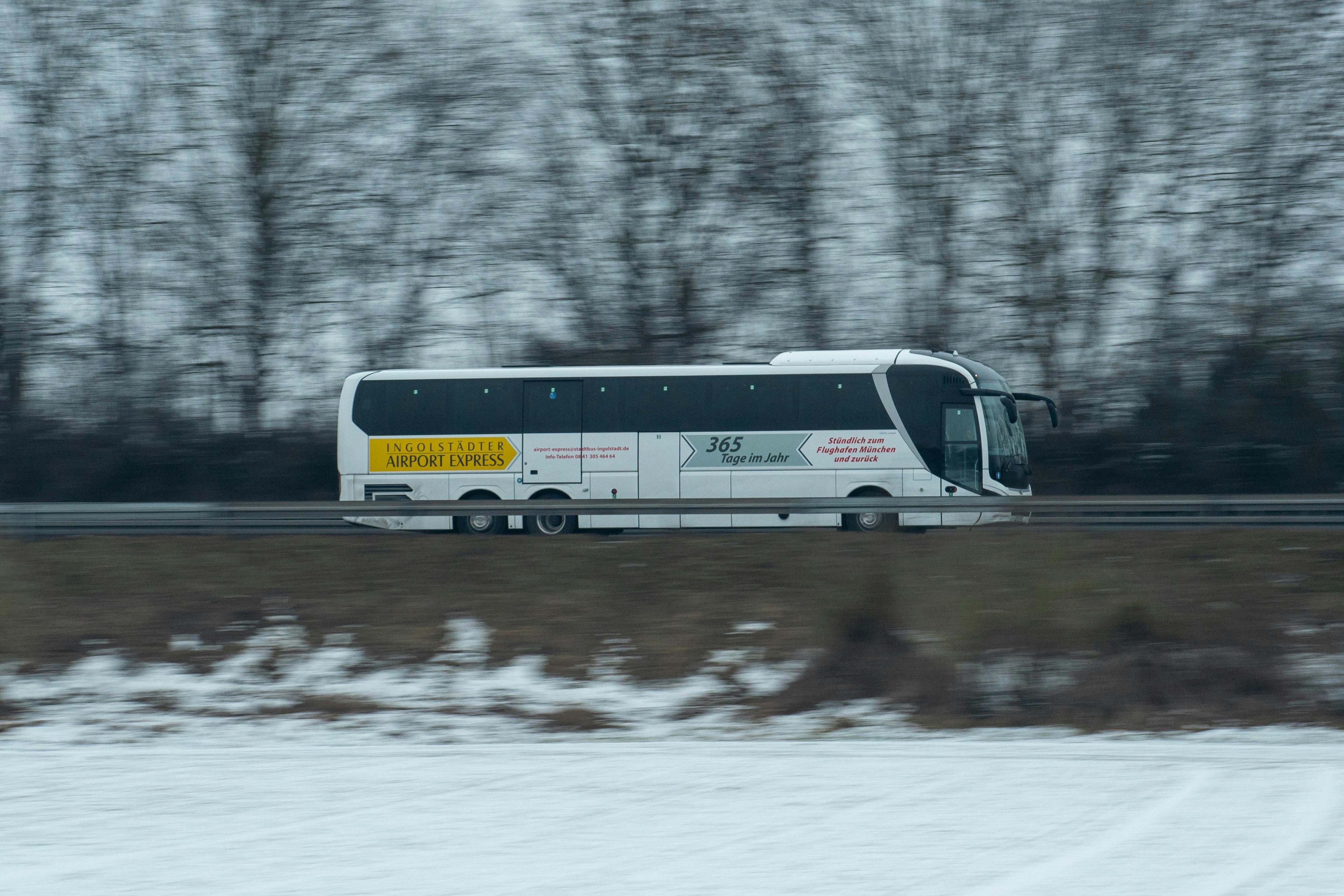 bezplatná Dynamický záběr autobusu Ingolstadt Airport Express, který se řítí zasněženou krajinou. Základová fotografie