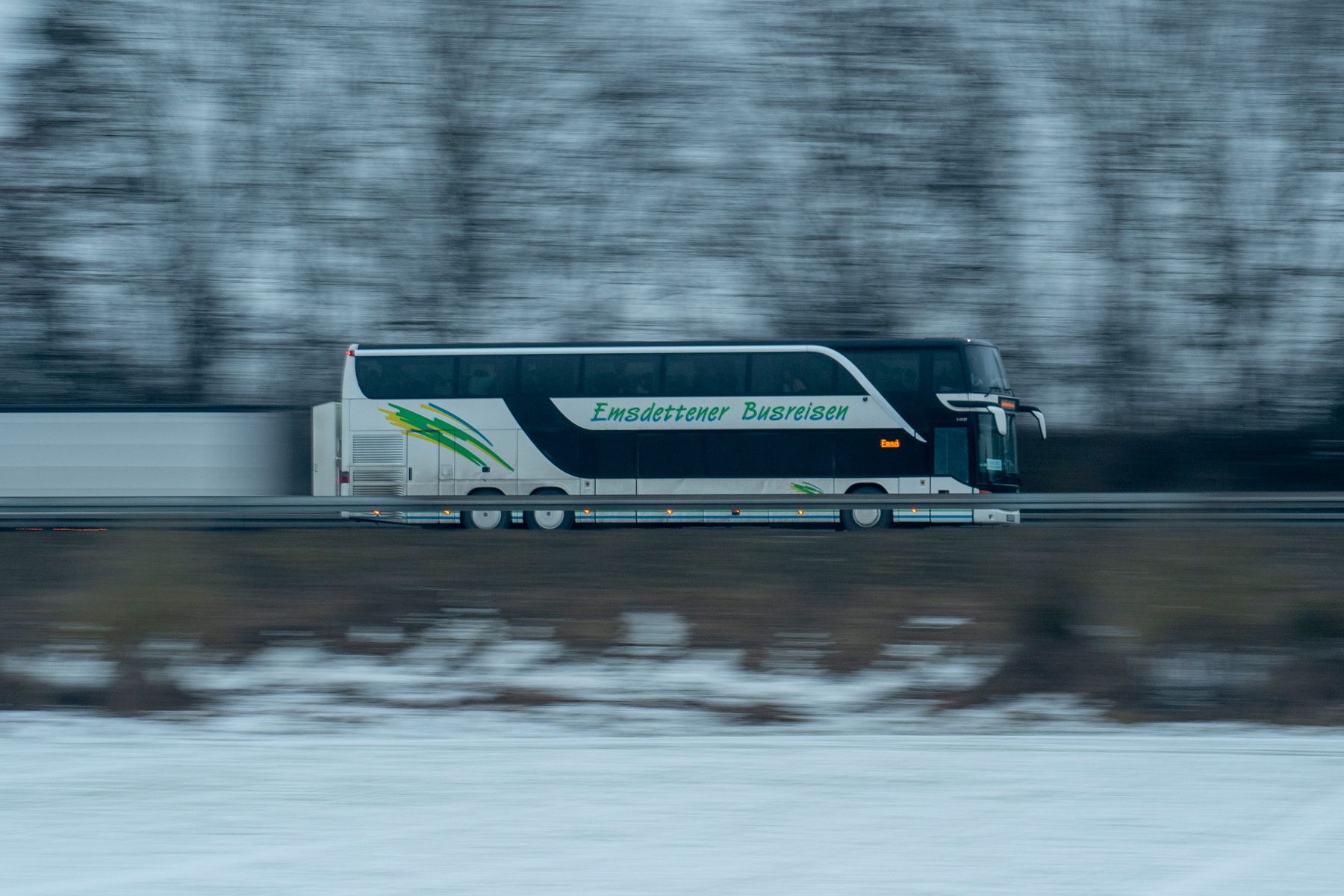 Bus de pasajeros en marcha por una carretera, captado con barrido de movimiento