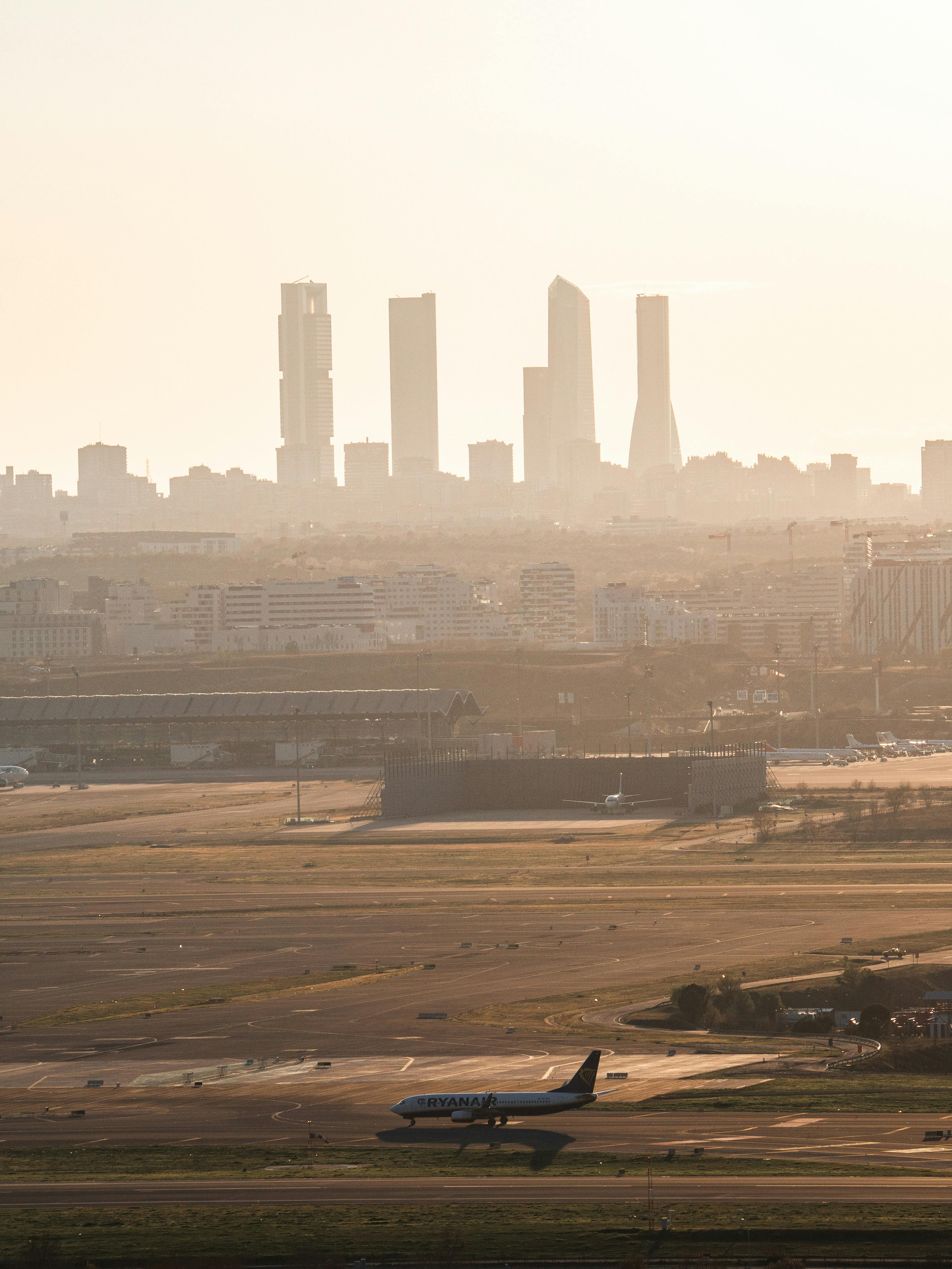 免费 马德里天际线的全景图，日落时分飞机滑行，捕捉了城市和航空元素。 素材图片