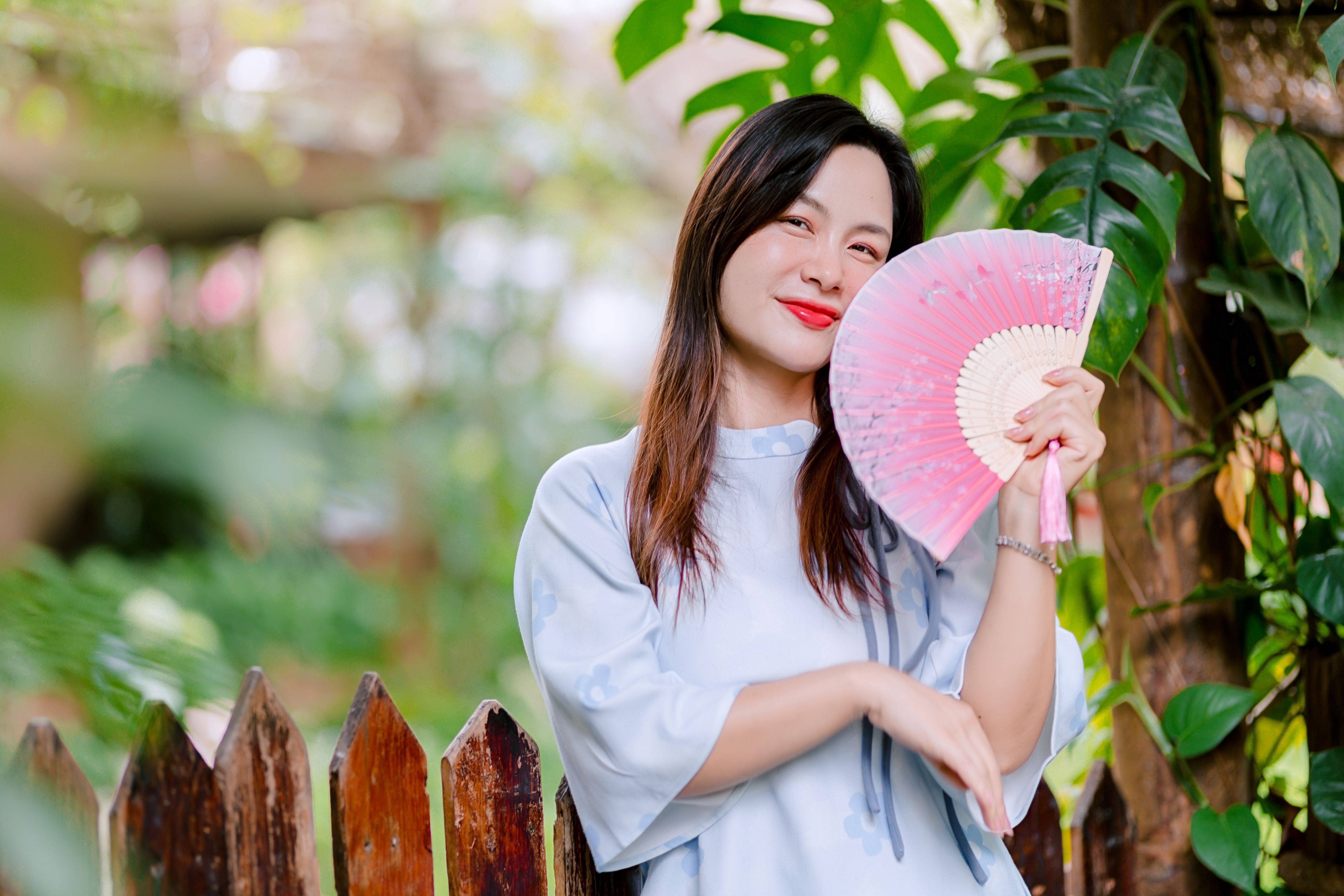Woman in White Dress Using Portable Fan Outdoors · Free Stock Photo