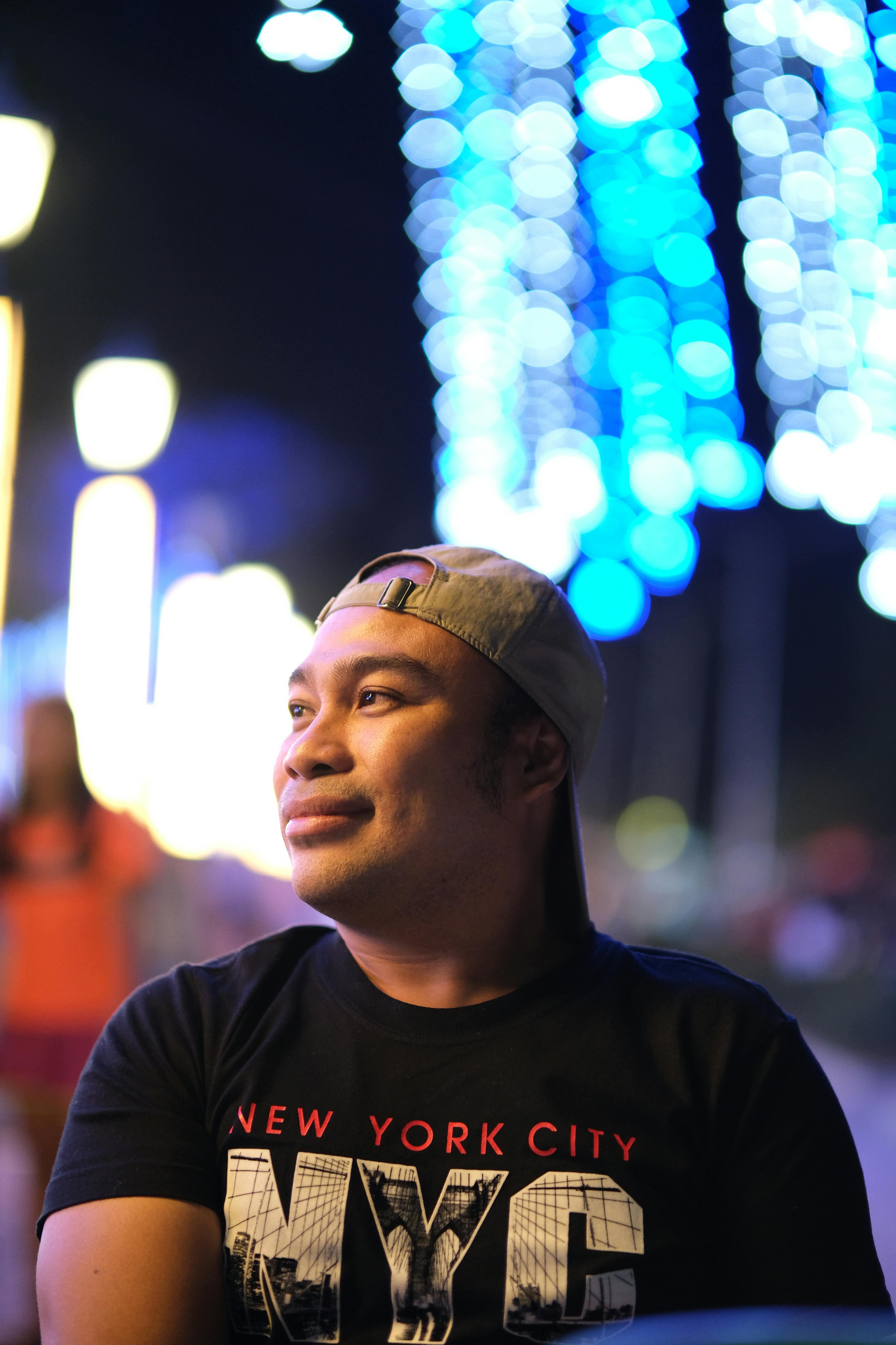 De franc Retrat d'un home a la nit amb un bokeh de llum blava vibrant creant una atmosfera urbana. Foto d'estoc