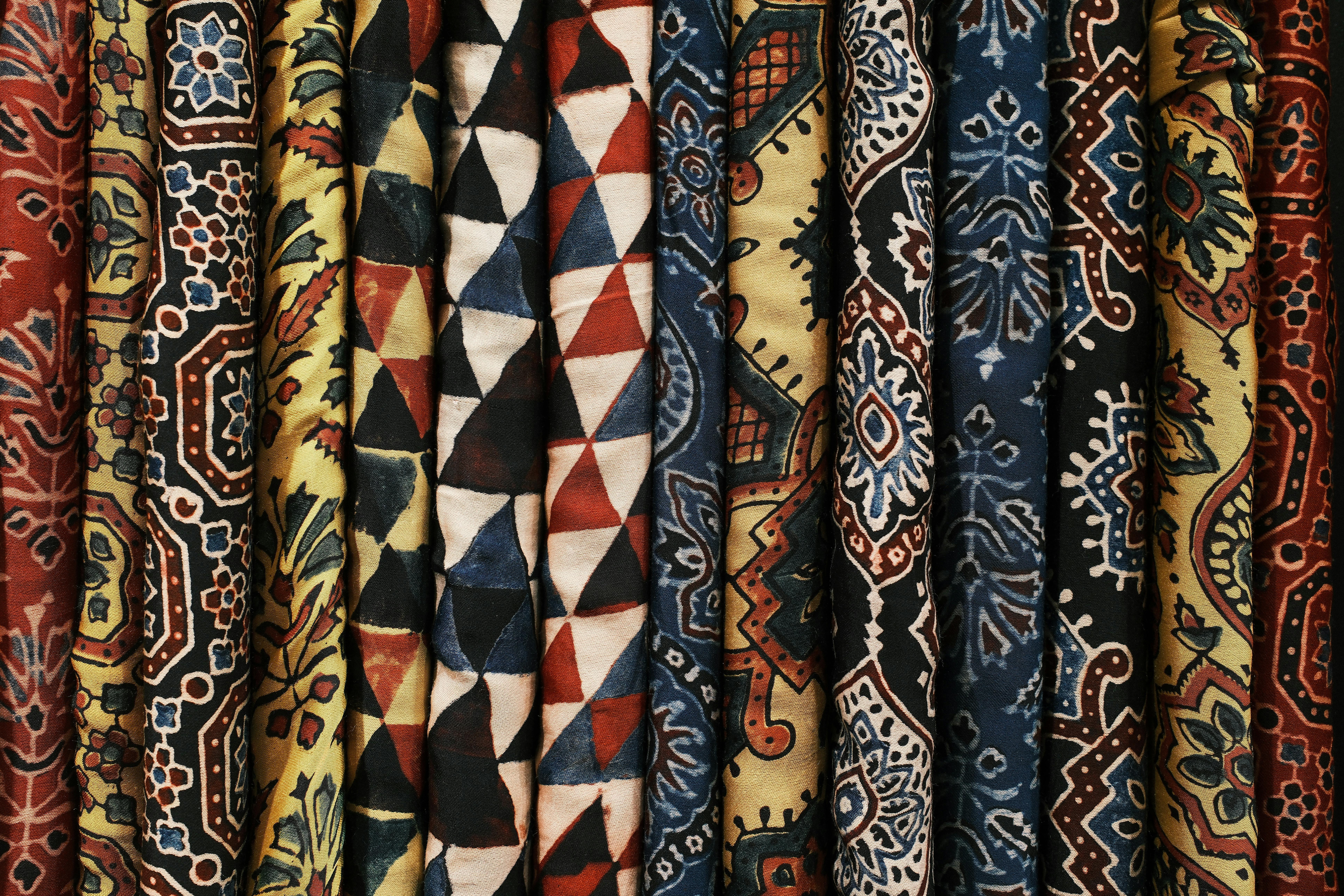 gratis Een gevarieerde collectie kleurrijke stoffen met patronen die ingewikkelde ontwerpen en texturen laten zien. Stockfoto