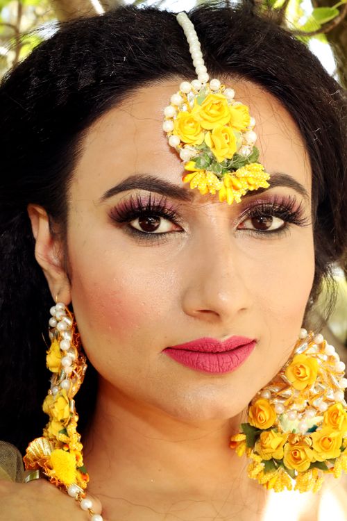 Free A close-up portrait of a woman wearing intricate floral jewelry, outdoors. Stock Photo