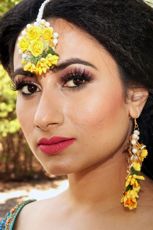 Free A stunning close-up portrait of a woman wearing traditional yellow floral jewelry. Stock Photo