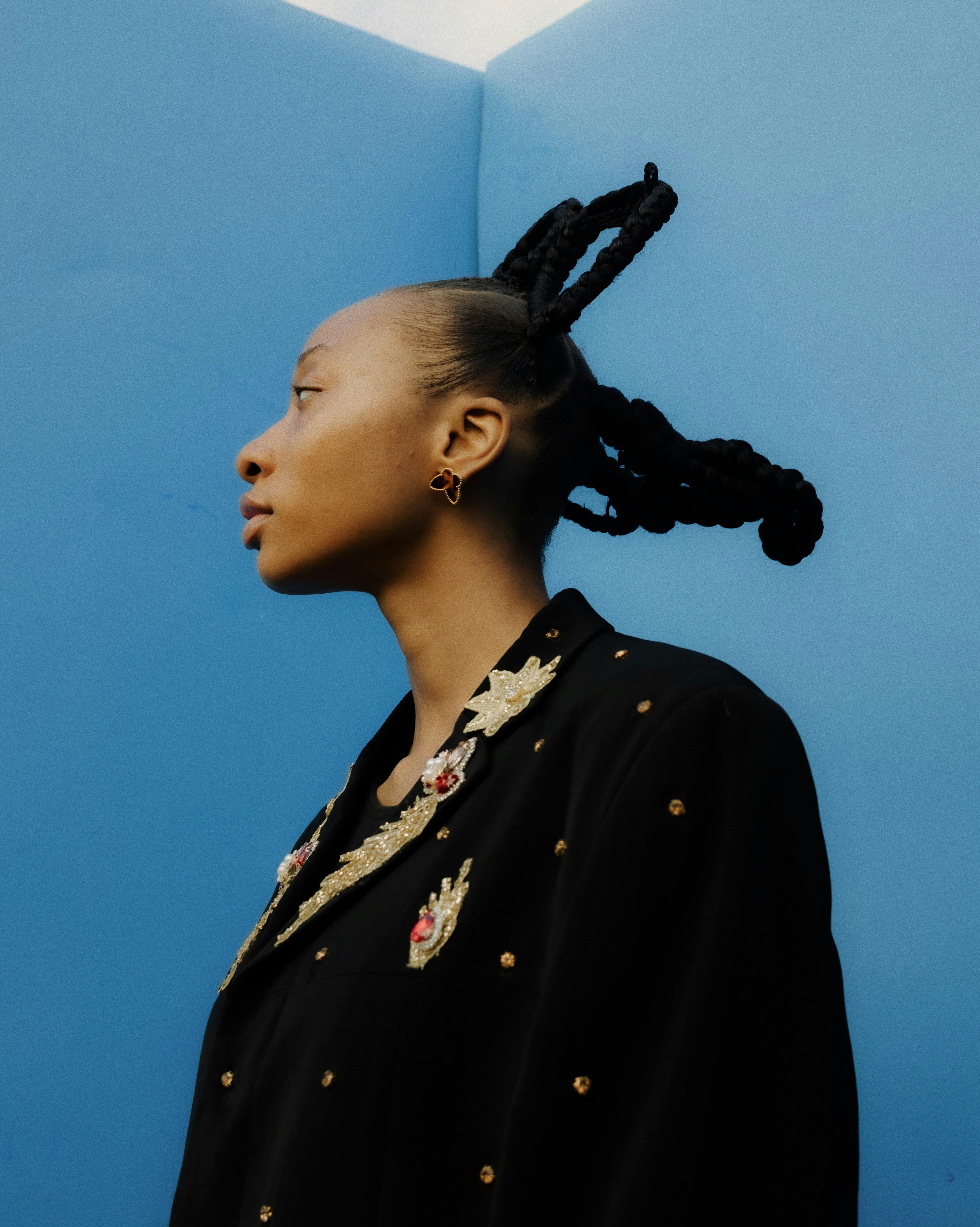 gratis Portret van een stijlvolle vrouw in geborduurde kleding tegen een levendige blauwe achtergrond in Nigeria. Stockfoto