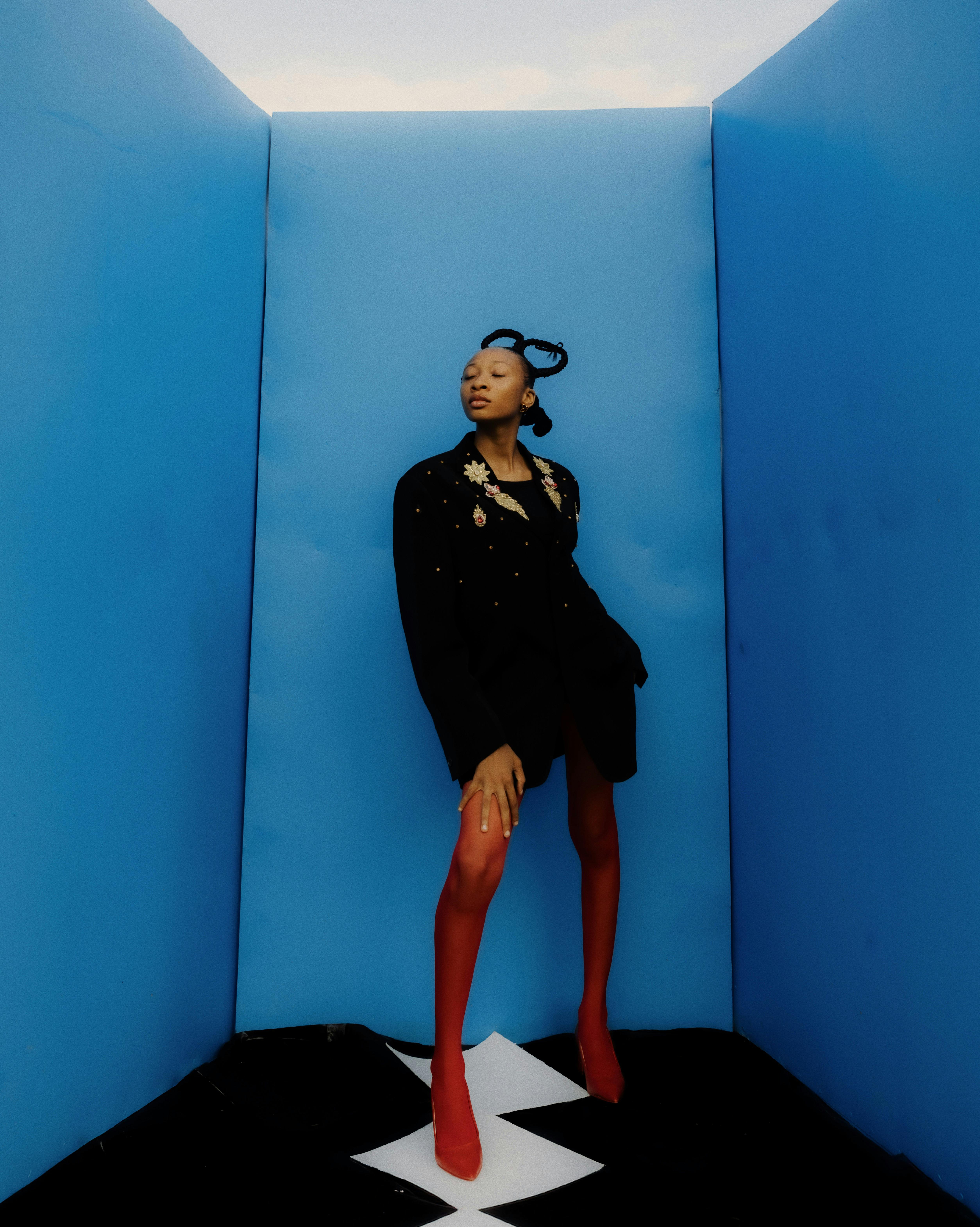 ingyenes Divatmodell feltűnő piros-kék összeállításban pózol, magabiztosságot és stílust sugározva. Stockfotó