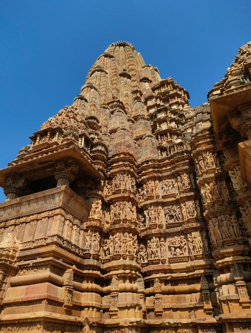 Free Stunning view of the elaborate carvings on a Khajuraho temple under a clear blue sky. Stock Photo