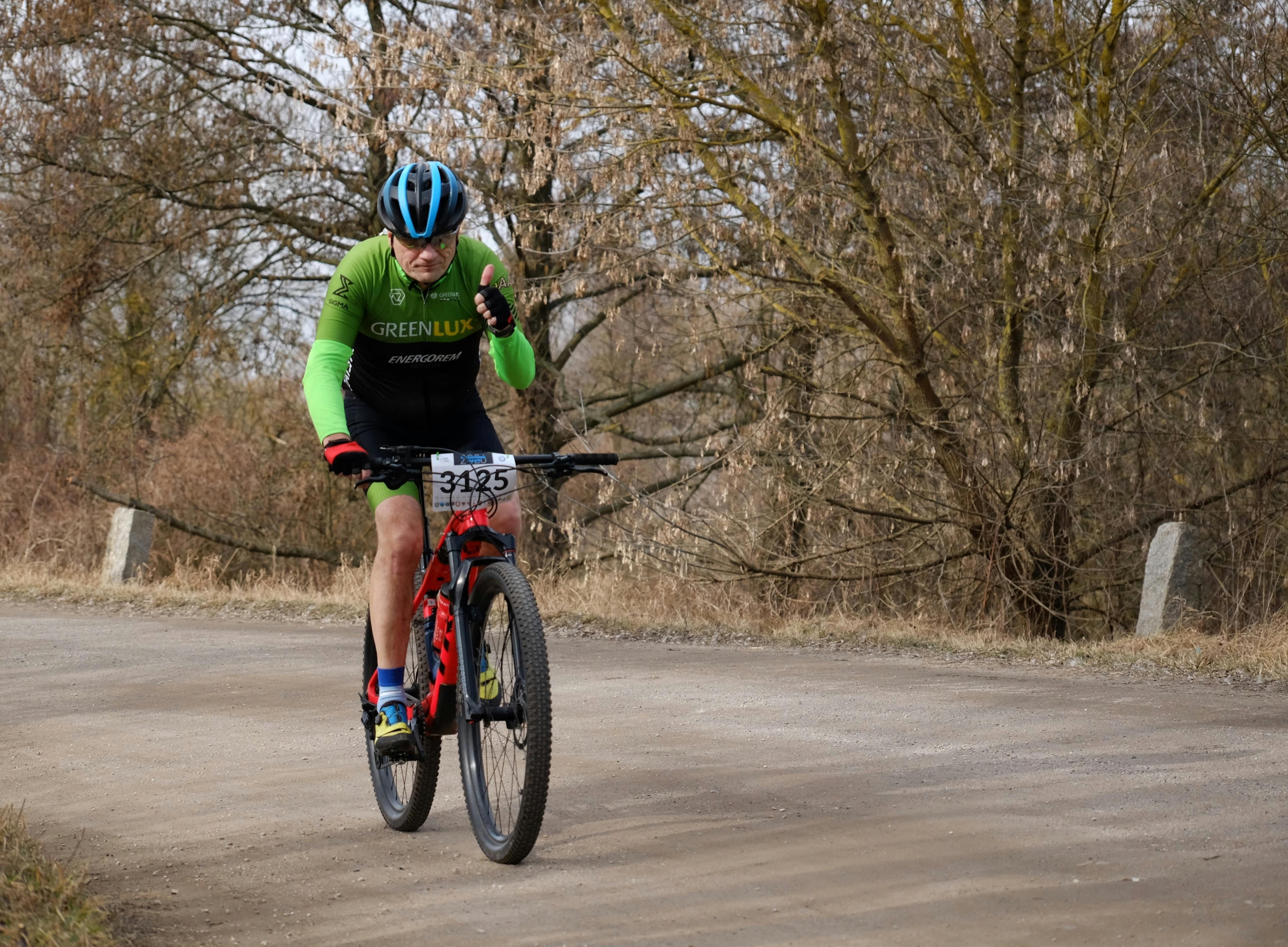 Gratis Un atleta senior partecipa a una gara di mountain bike su un percorso rurale, dimostrando resistenza e determinazione. Foto a disposizione