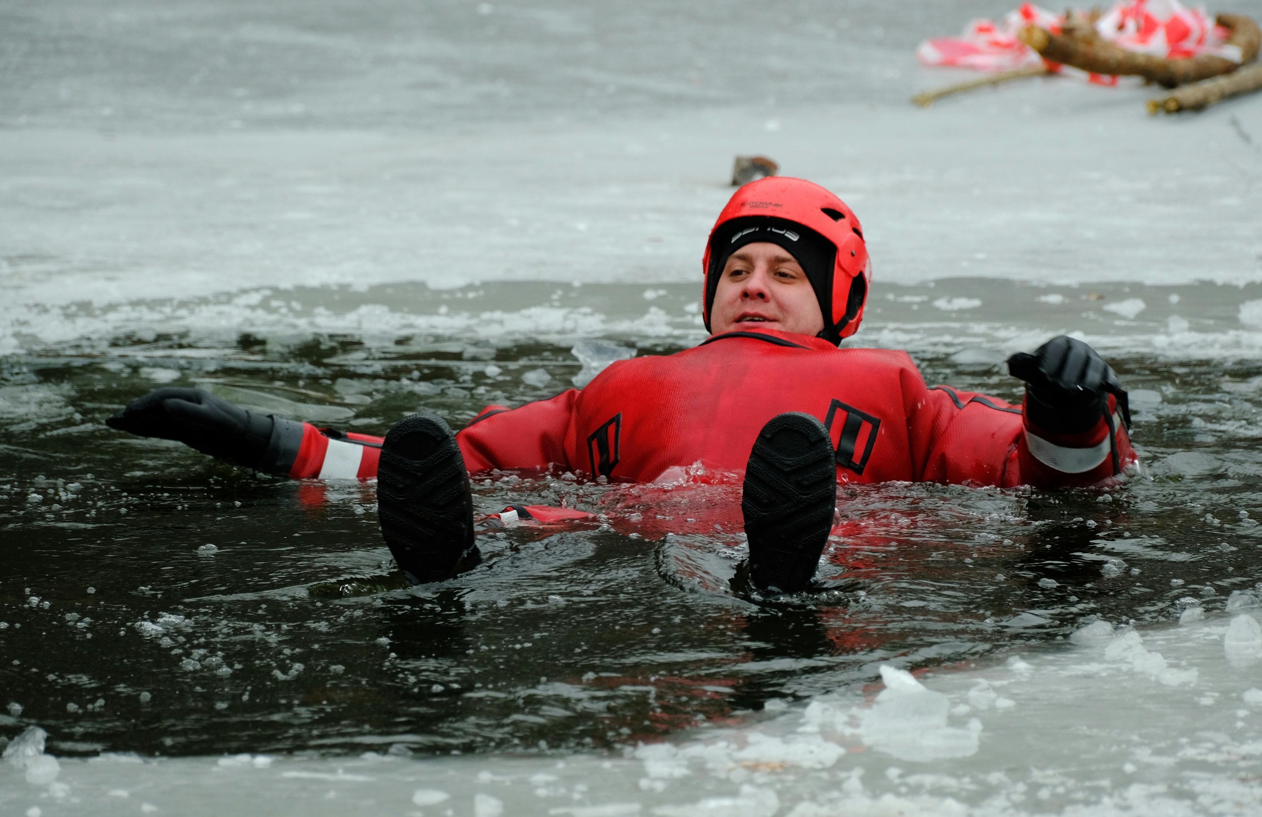 Gratuit Bărbat adult practicând tehnici de salvare de pe gheață într-un costum de supraviețuire roșu pe un lac înghețat. Fotografie de stoc