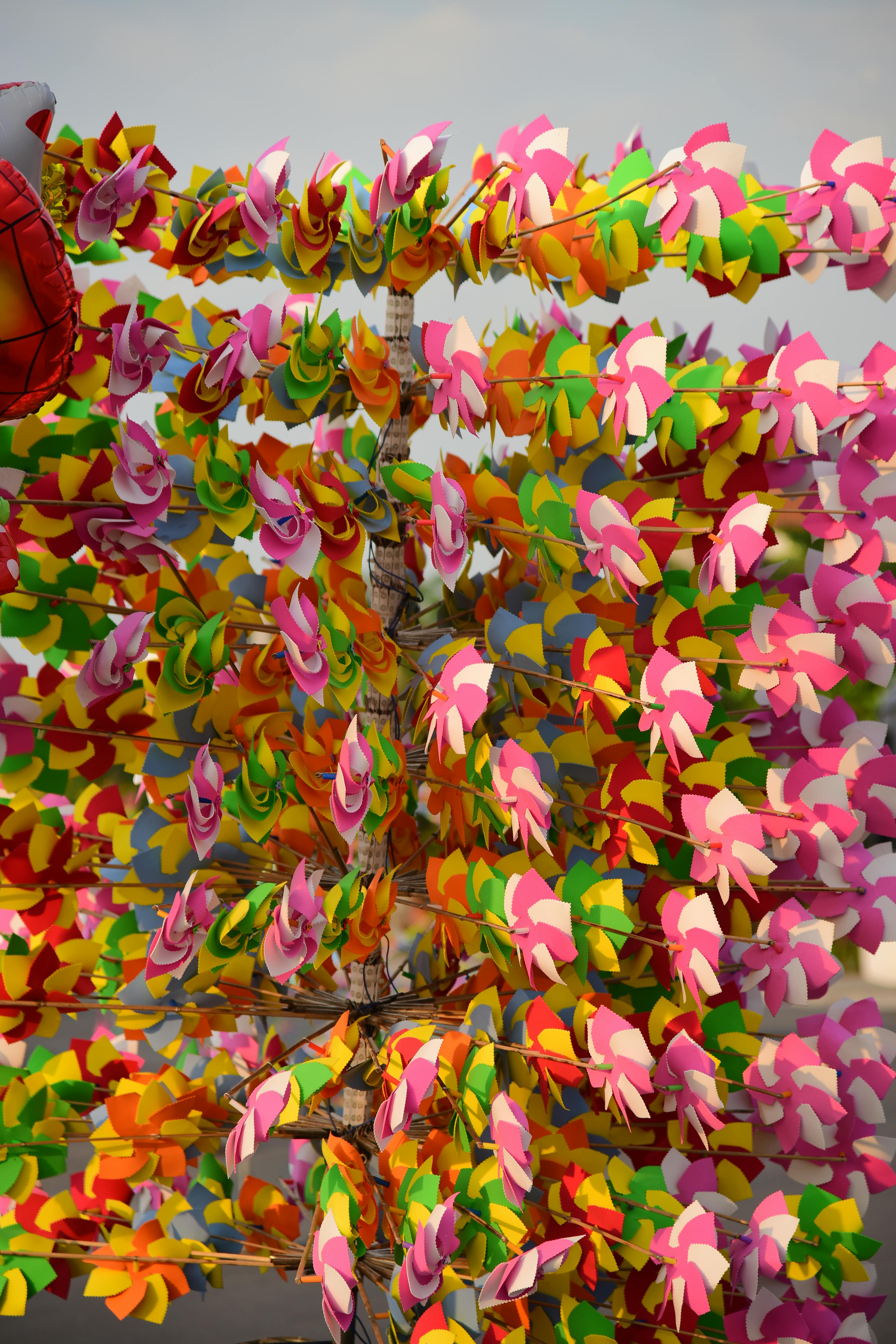 Gratuit Aranjament vibrant de mori de vânt colorate sub cerul albastru, ideal pentru conținut festiv sau cu tematică de carnaval. Fotografie de stoc