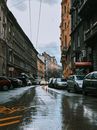 布达佩斯的城市街道在雨天道路潮湿，两旁有汽车和历史建筑