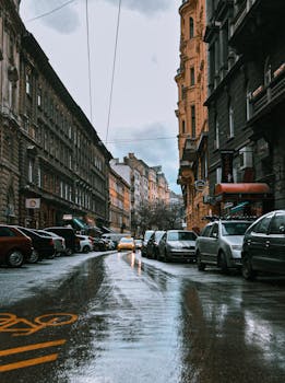 布达佩斯的城市街道在雨天道路潮湿，两旁有汽车和历史建筑