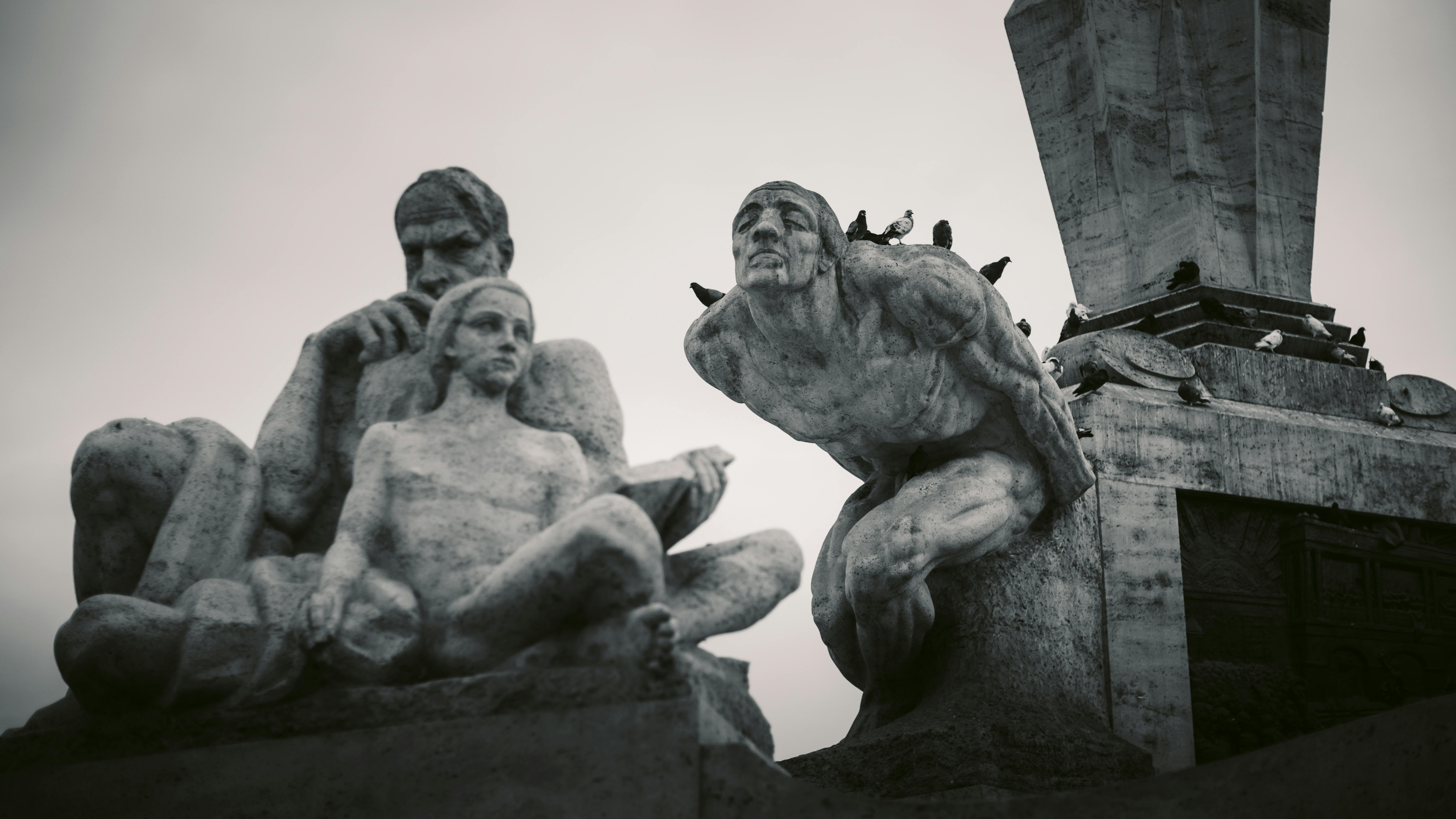 Gratis Una suggestiva fotografia in bianco e nero di una scultura in pietra ricca di dettagli, con uccelli appollaiati sulla sommità. Foto a disposizione