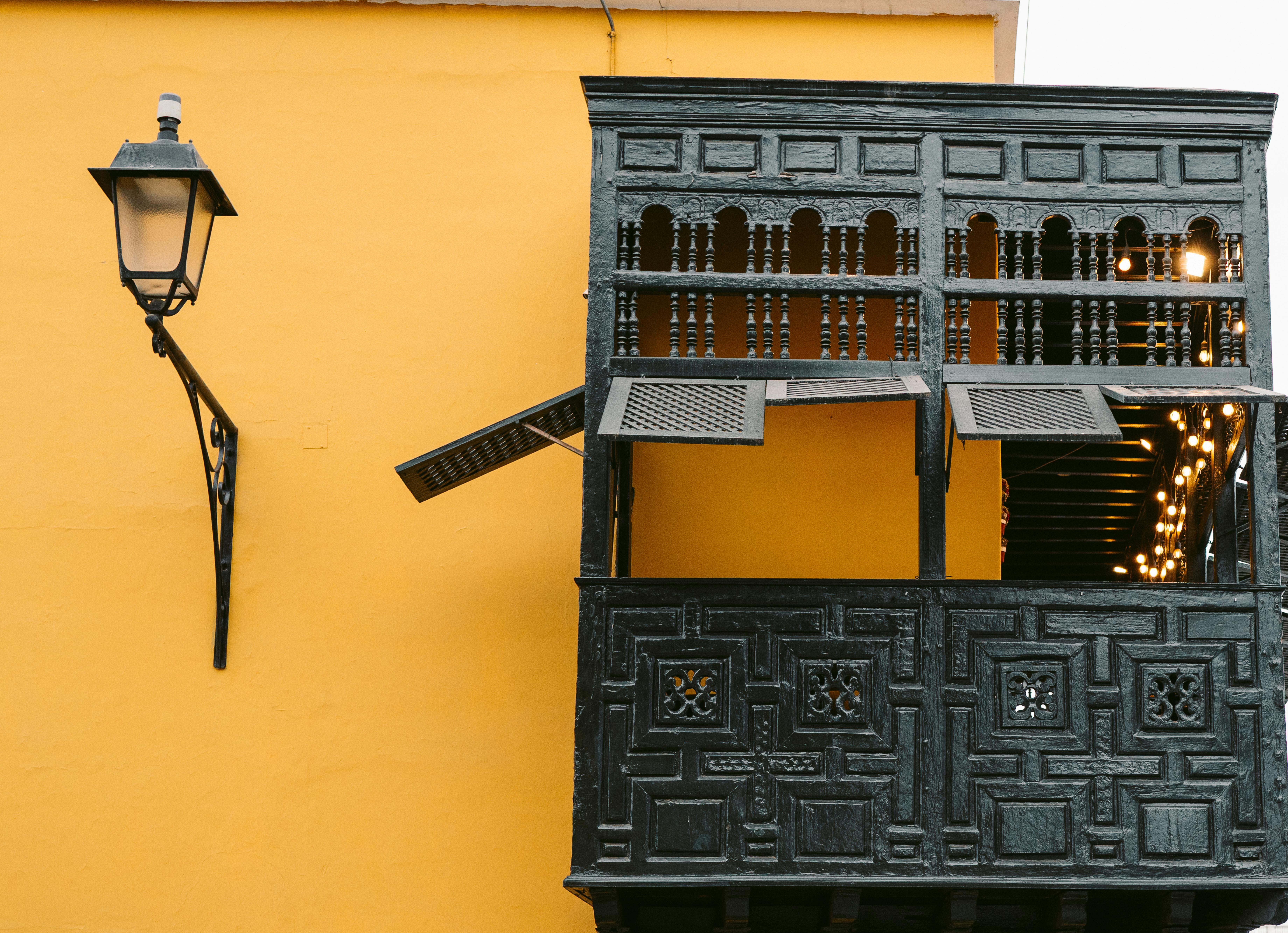 Ücretsiz Peru'nun Trujillo kentinde, canlı sarı bir duvar üzerinde yer alan tarihi ahşap balkon. Stok Fotoğraflar