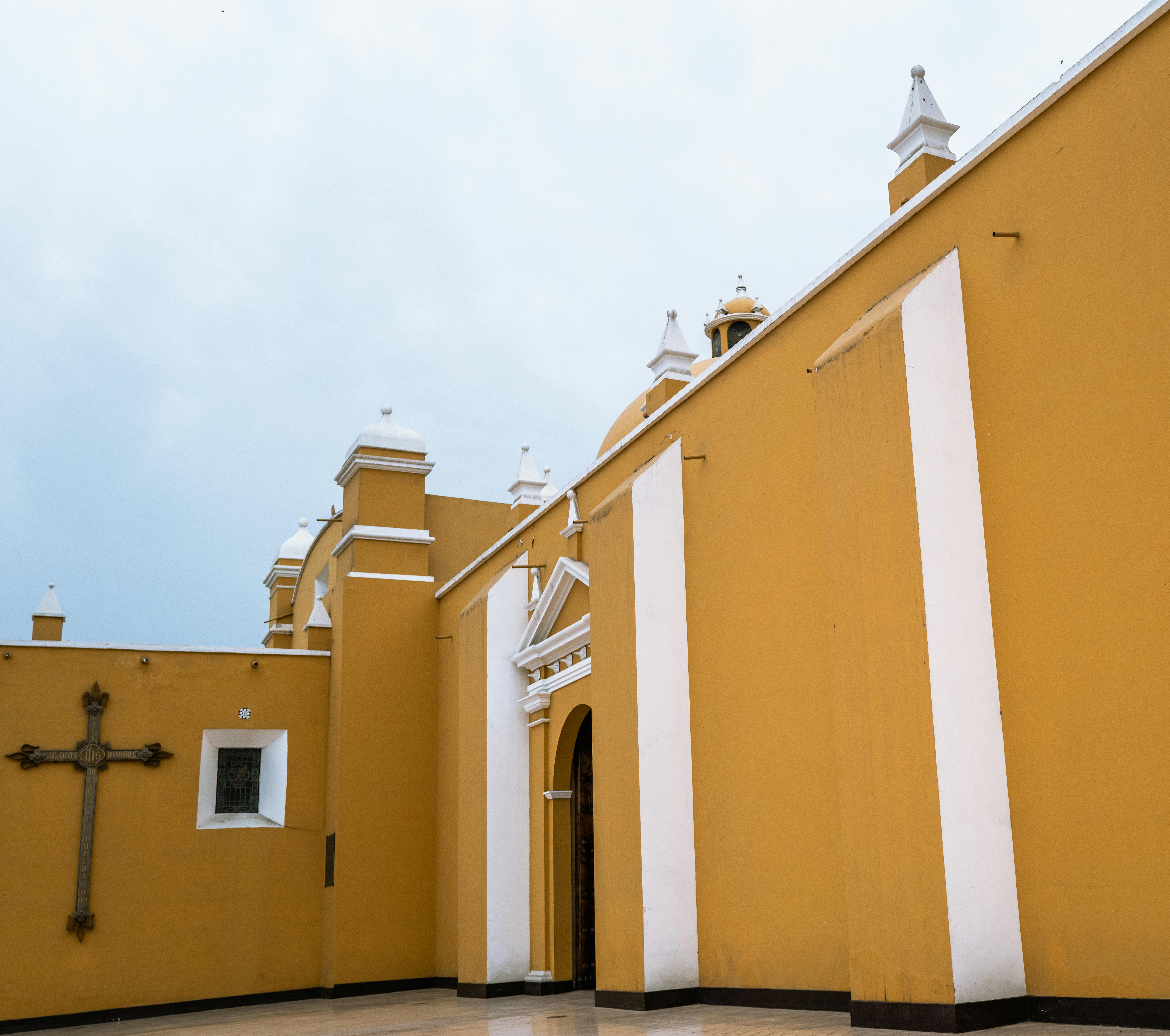 Gratuit Fațadă galbenă vibrantă a unei biserici coloniale din Trujillo, Peru, pe fundalul unui cer înnorat. Fotografie de stoc
