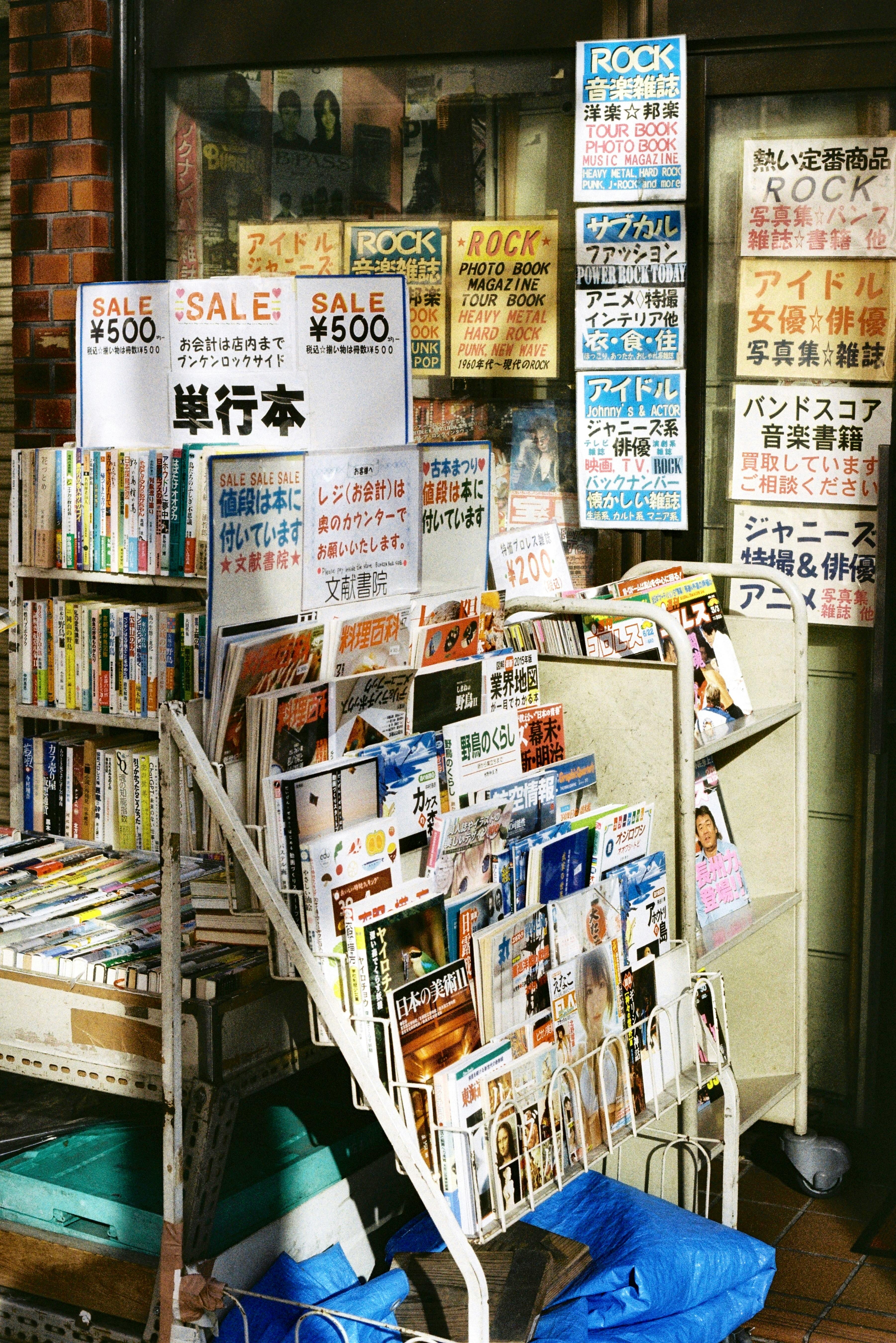 Gratis Bøger og blade udstillet uden for en boghandel i Tokyo, der viser lokale publikationer og udsalg. Lagerfoto