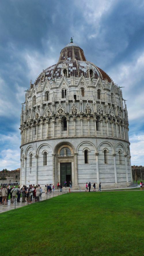 Free The Pisa Baptistery in Italy stands majestically under a dramatic sky, showcasing its stunning architecture. Stock Photo
