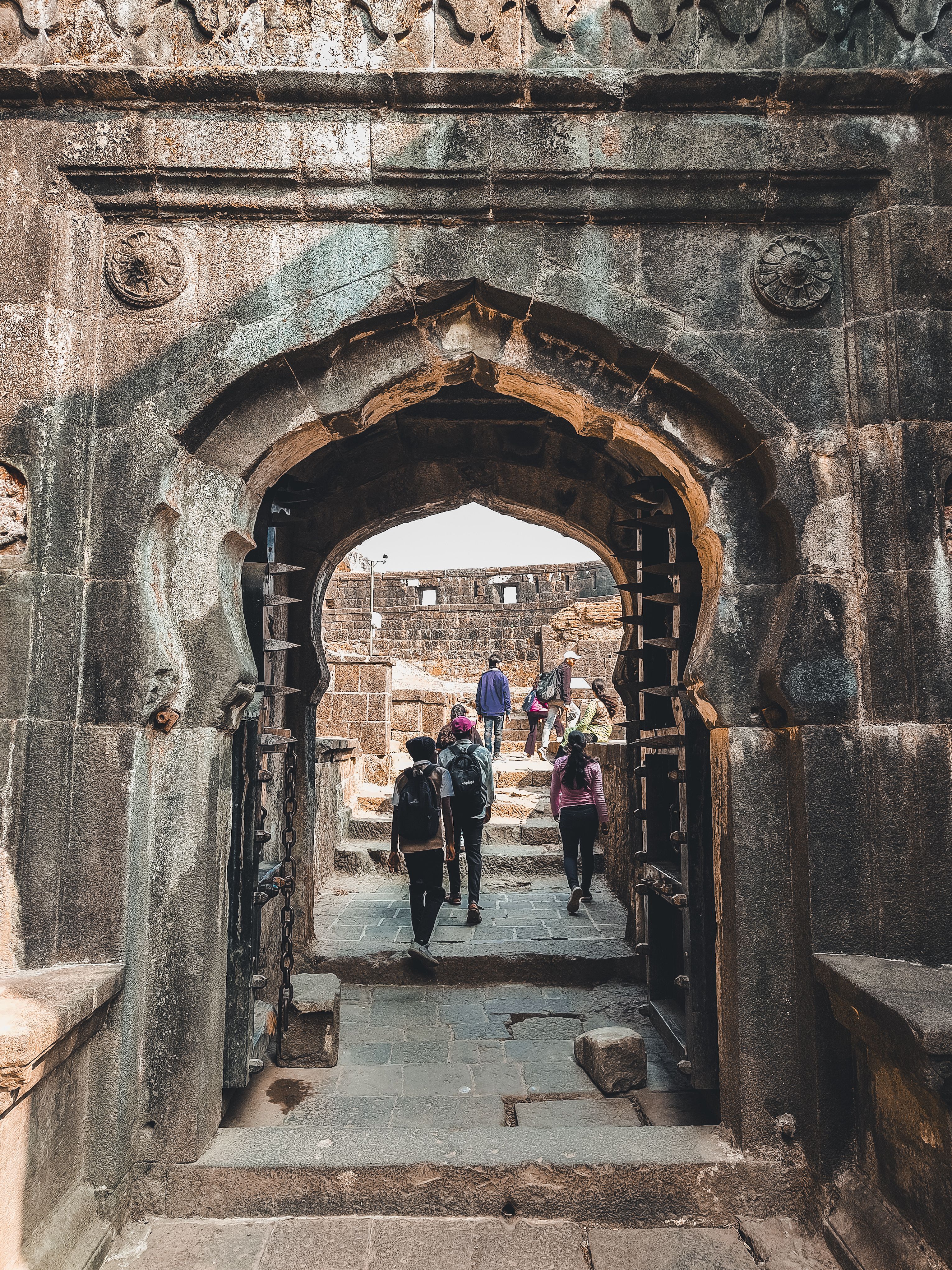 Tourists Exploring Historical Stone Fort Entrance · Free Stock Photo