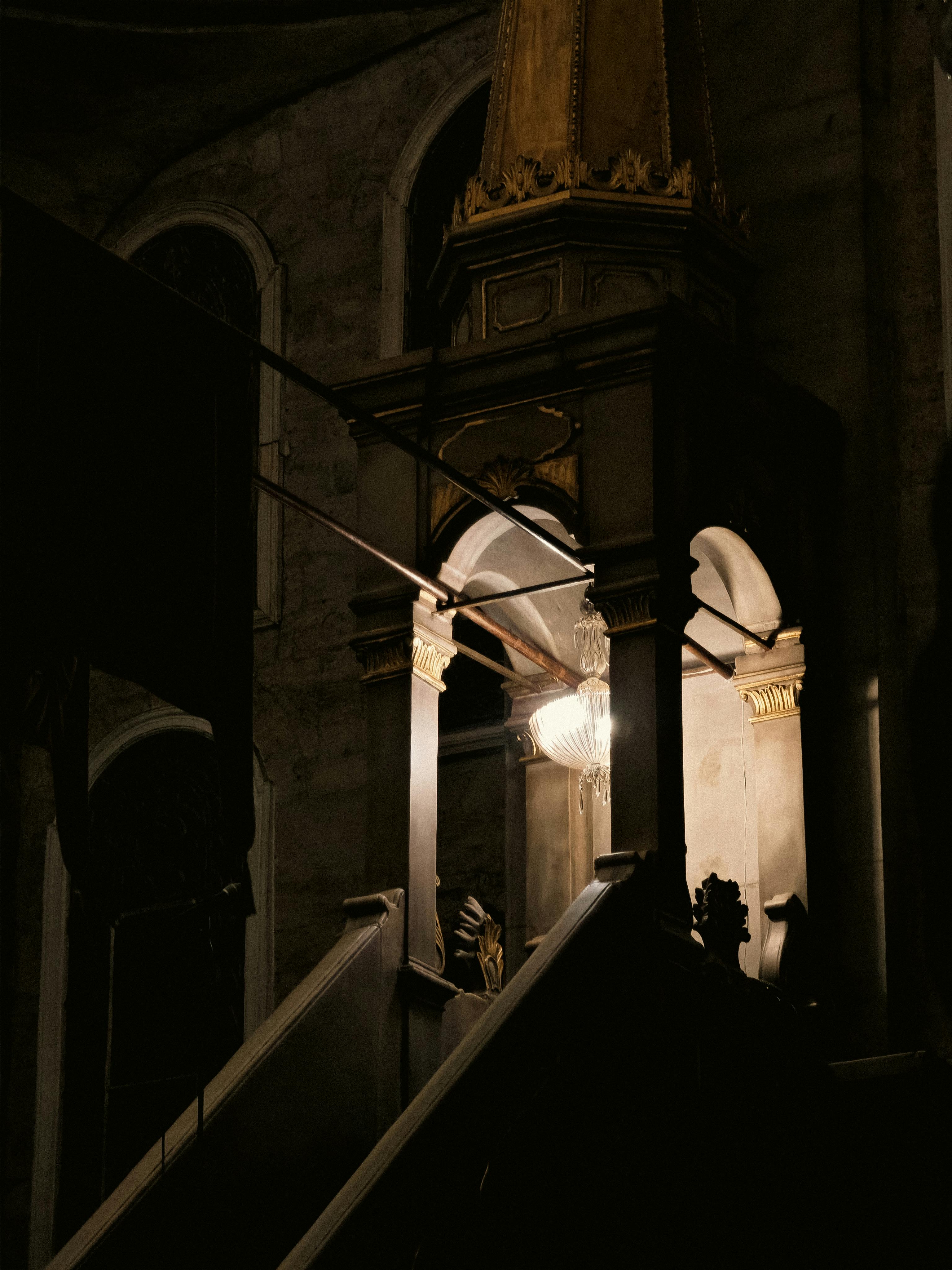 Zadarmo Slabo osvetlený interiér s historickou architektúrou a lustrom. Fotka z fotobanky